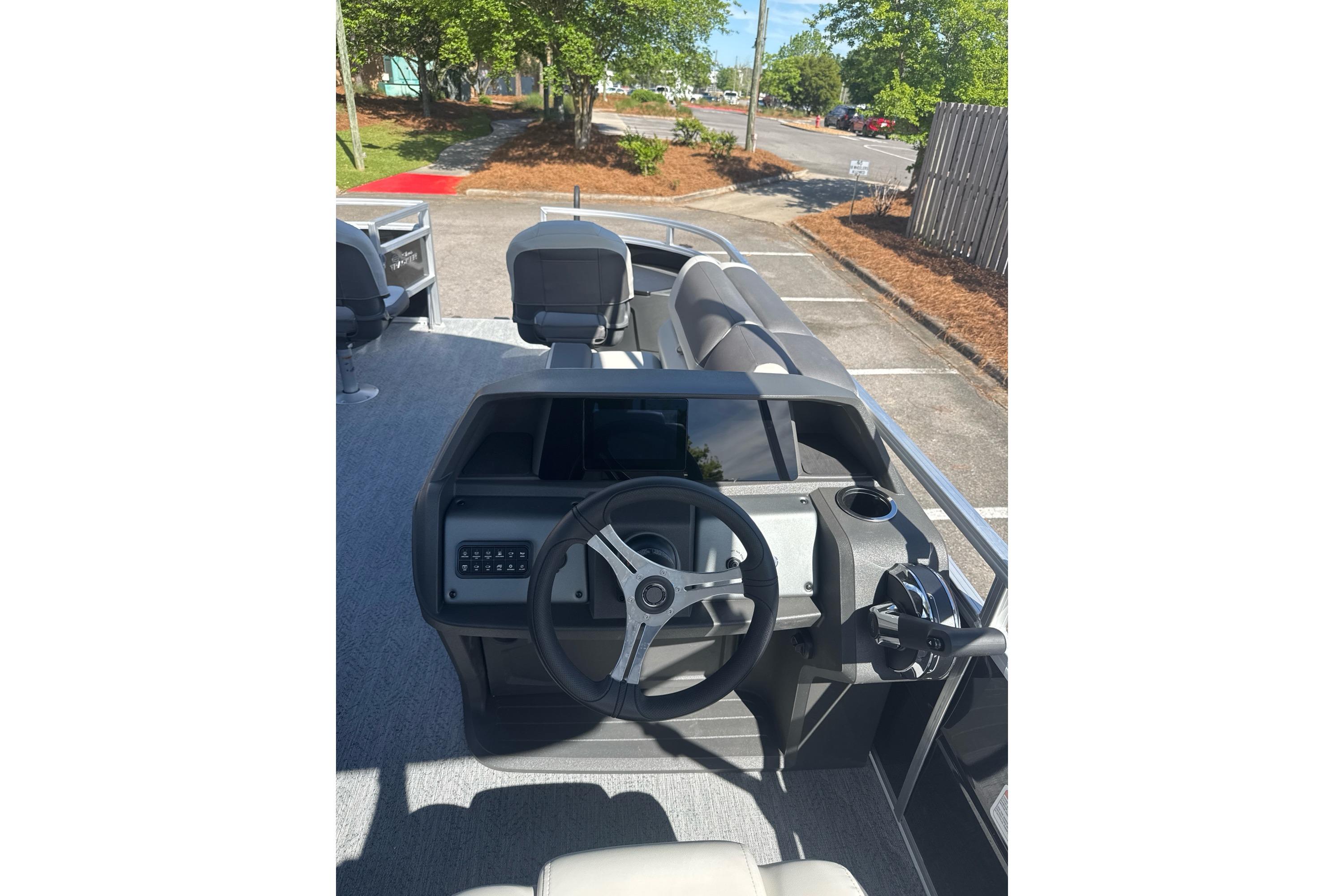 2026 Sun Tracker Fishin' Barge 20 DLX boat interior with steering wheel and seating.