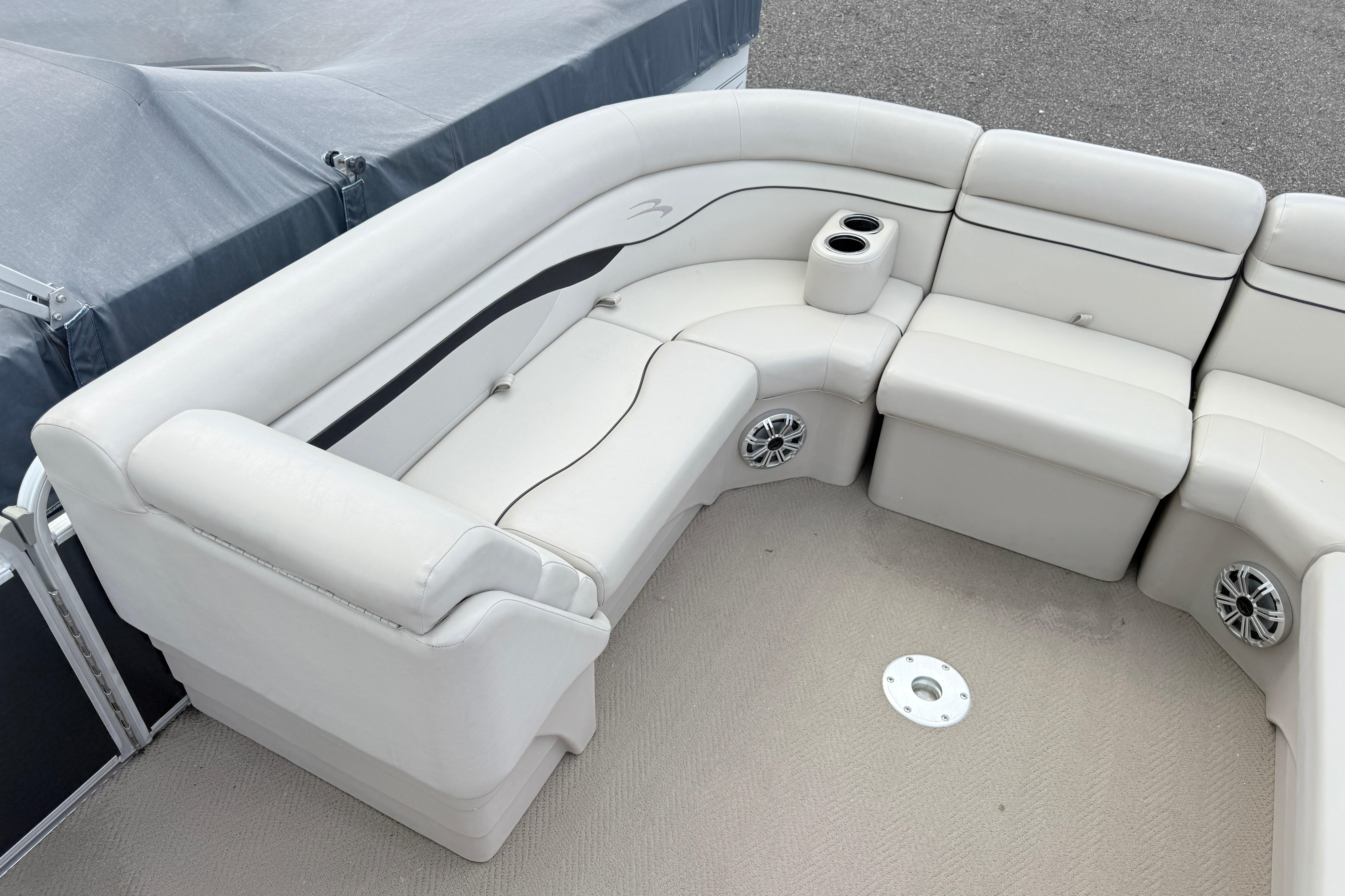 Luxurious seating on a 2015 Bennington 24SSLX pontoon boat with cup holders and speakers.