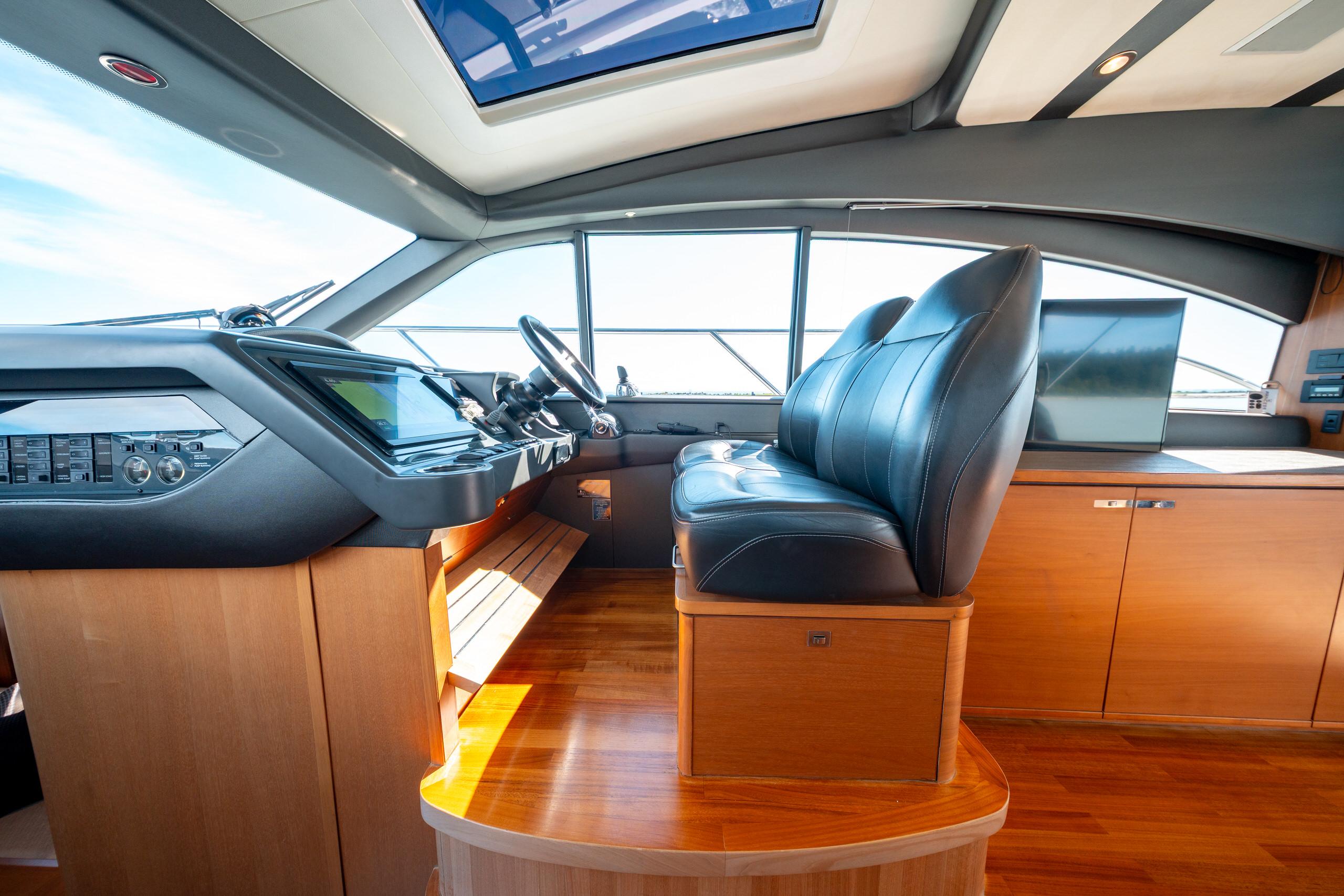 Interior of 2015 Princess V48 yacht with leather seating and modern dashboard.