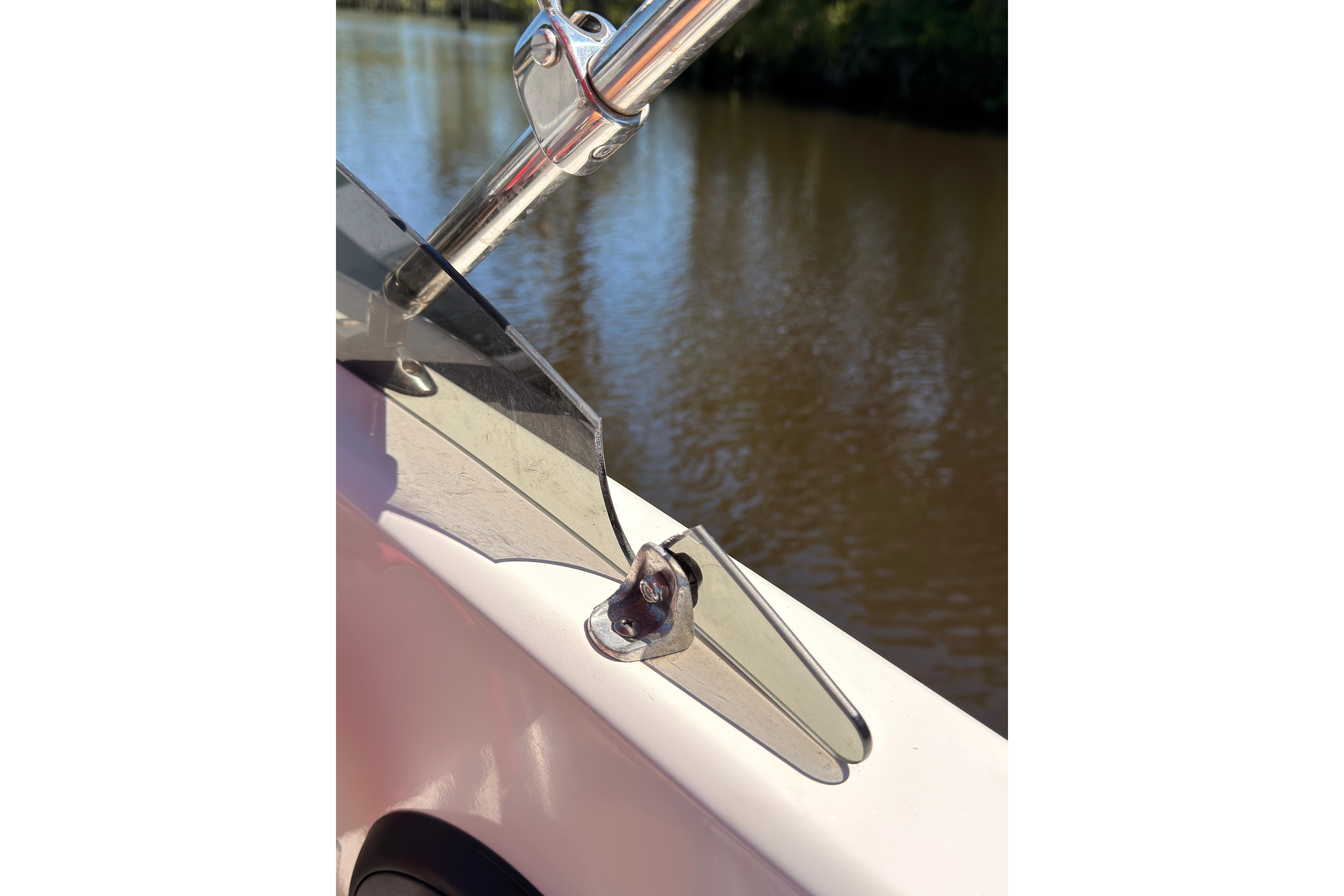 Close-up of 2022 Tahoe T18 boat windshield detail by a river.