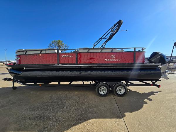 2023 Regency 250 DL3 pontoon boat with red and black design on a trailer.