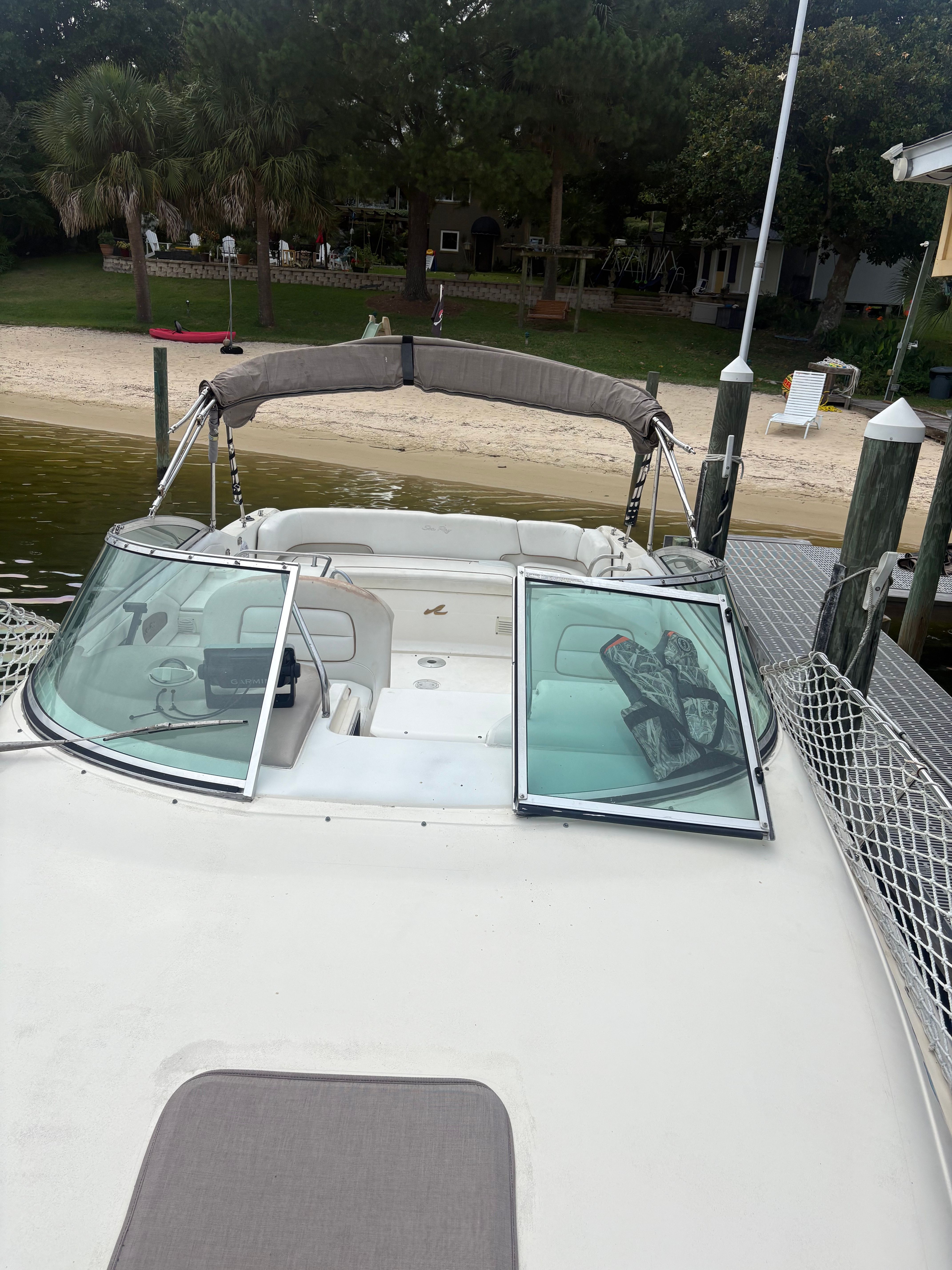A 1996 Sea Ray 280 Cuddy Cabin docked by a sandy beach.