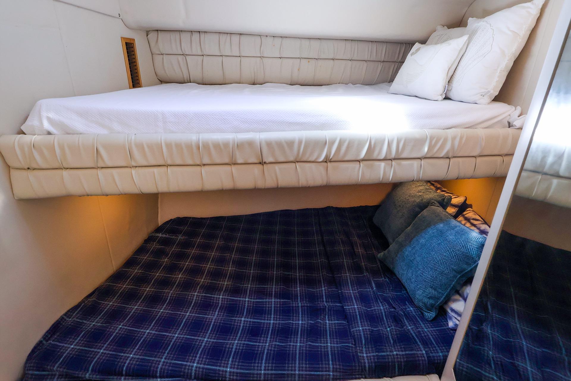 Interior cabin of 1998 Sea Ray 500 Sundancer with cozy bunk beds and pillows.