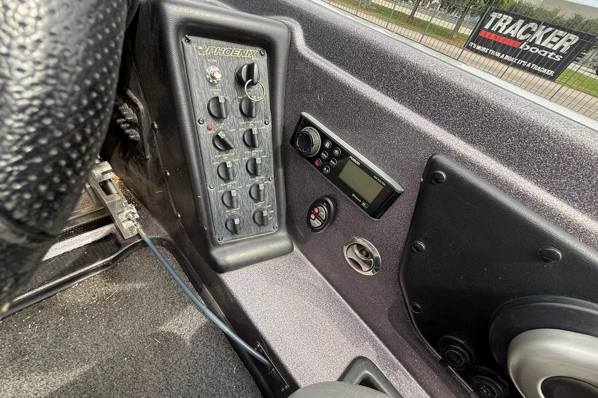 Control panel of a 2018 Phoenix 919 ProXP boat with switches and a display.