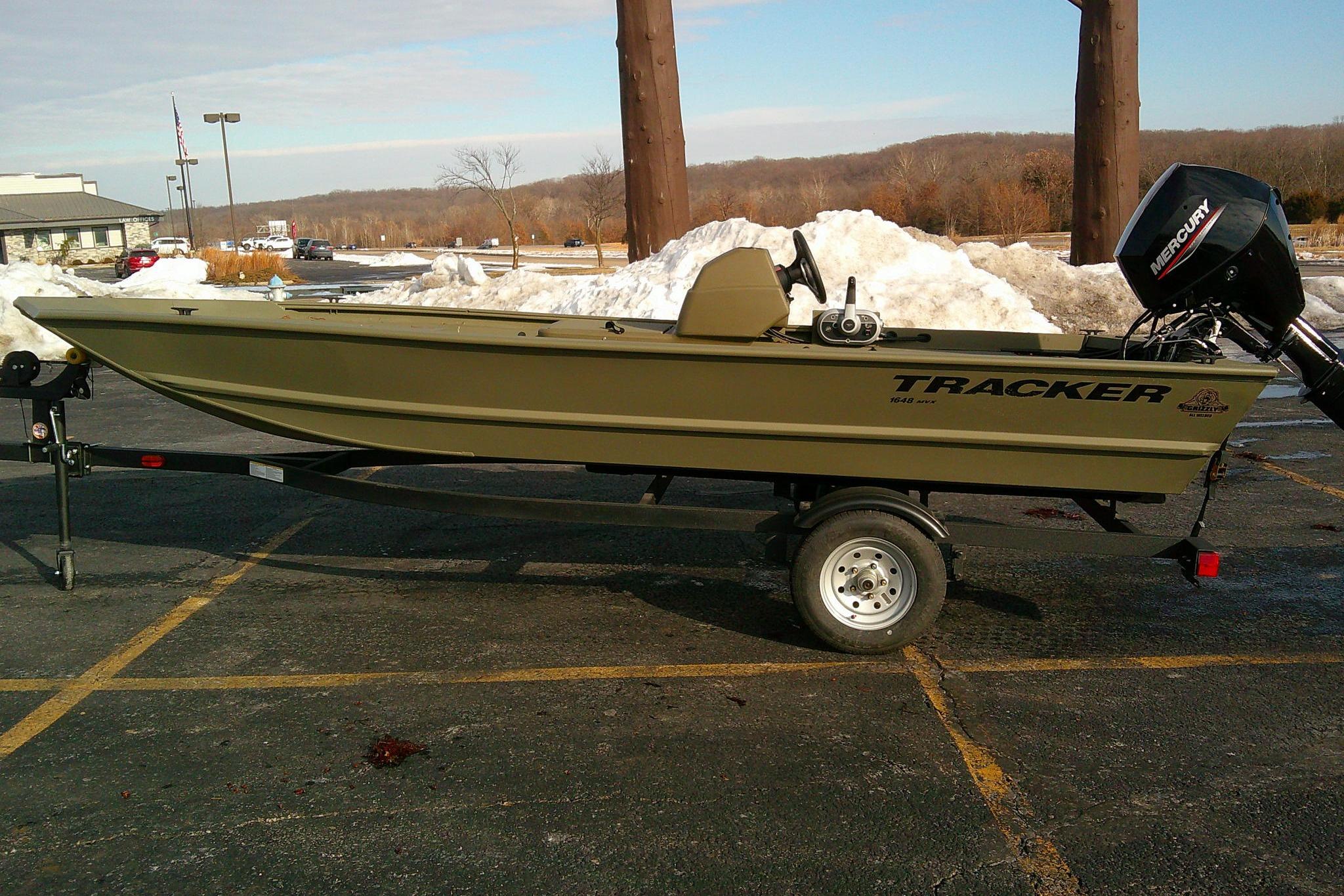 2025 Tracker Grizzly 1648 SC boat on trailer in snowy parking lot.