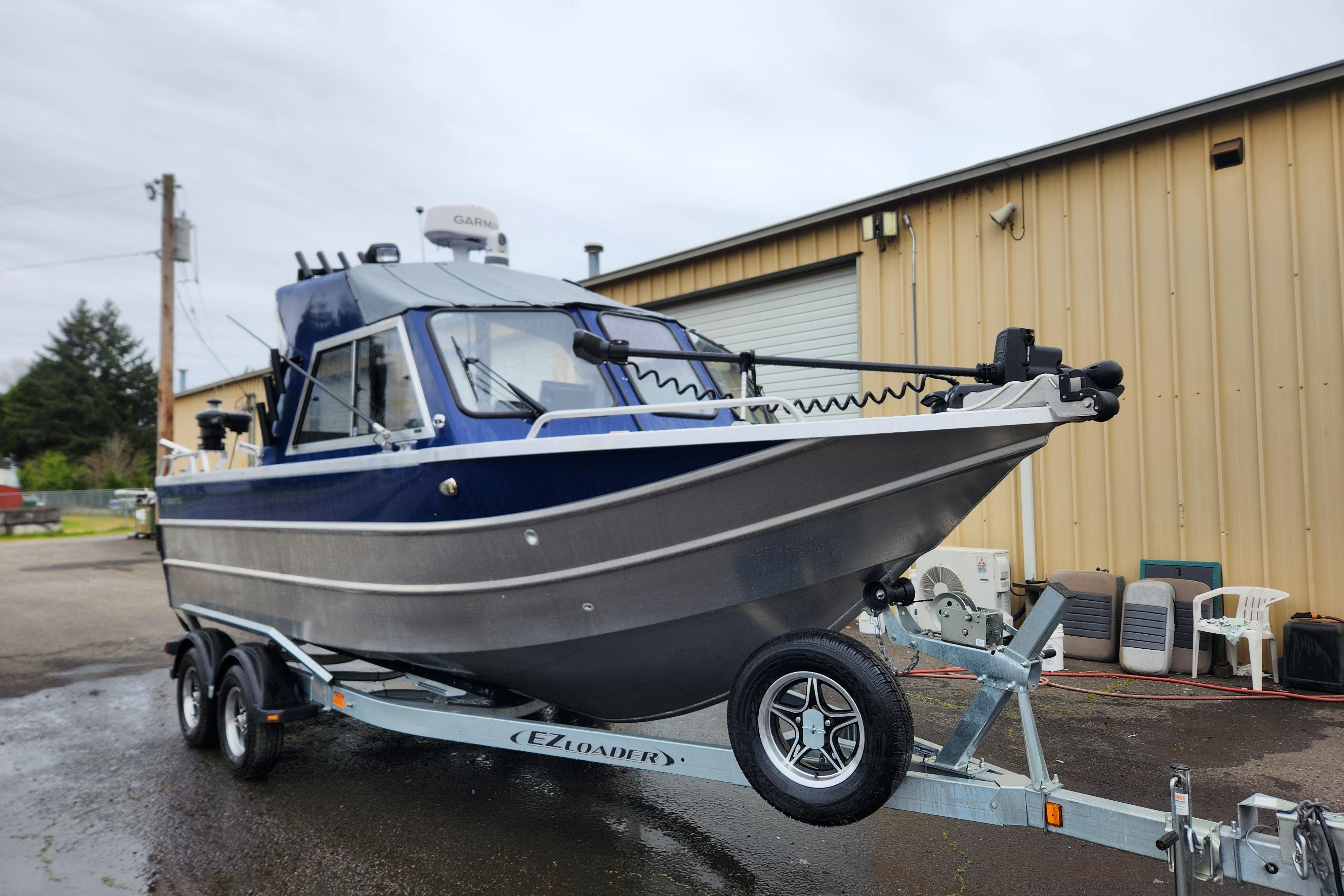 2025 Thunder Jet 21 Chinook OS boat on trailer, parked outside a warehouse.