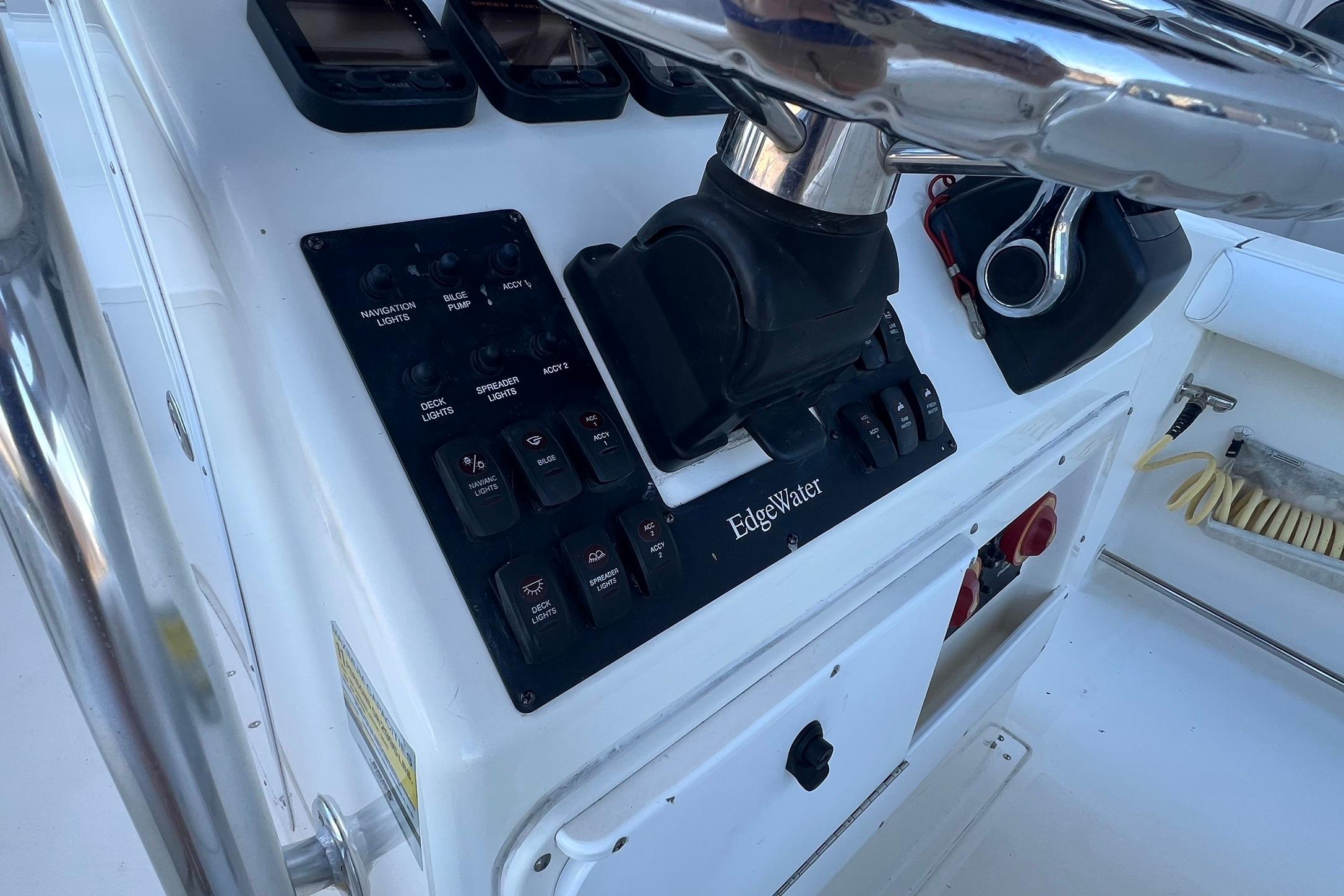 Edgewater 245CC 2006 boat dashboard with navigation controls and steering wheel.