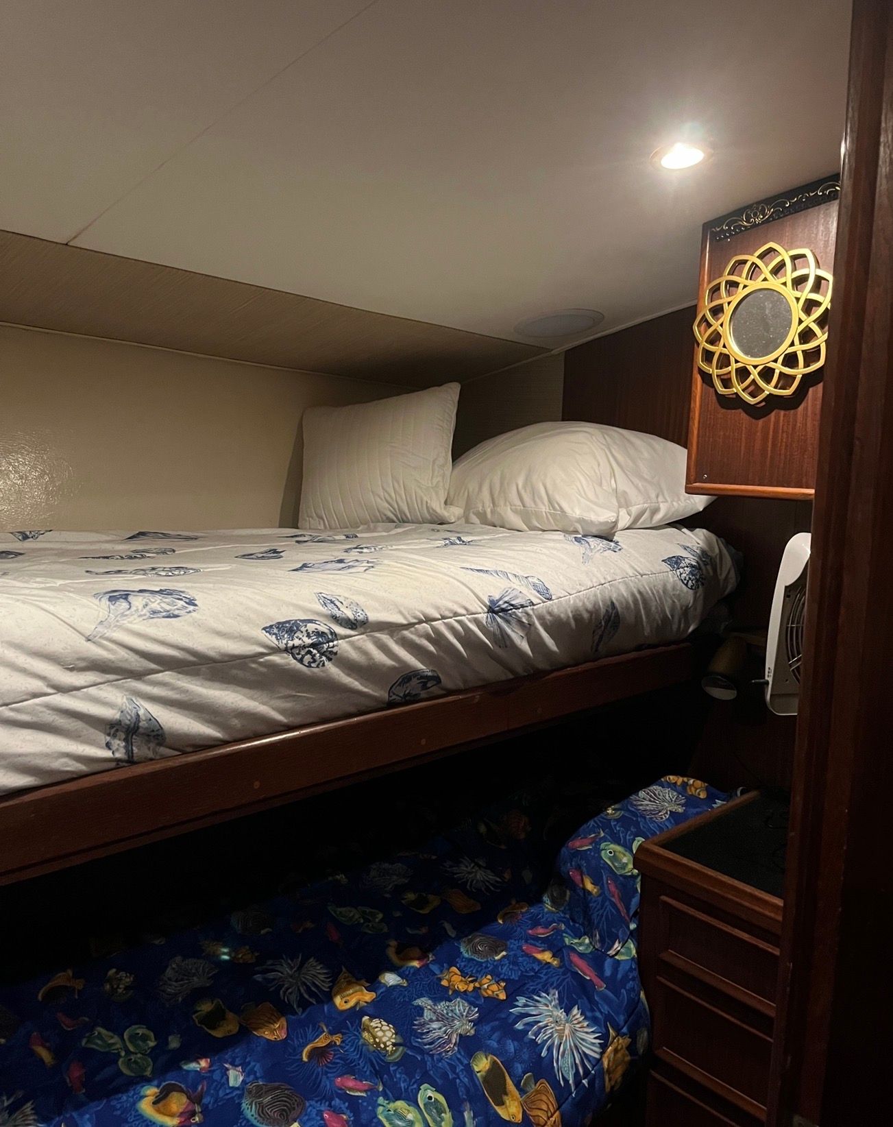 Interior of a Hatteras sport fishing boat cabin with bunk beds and nautical-themed bedding.