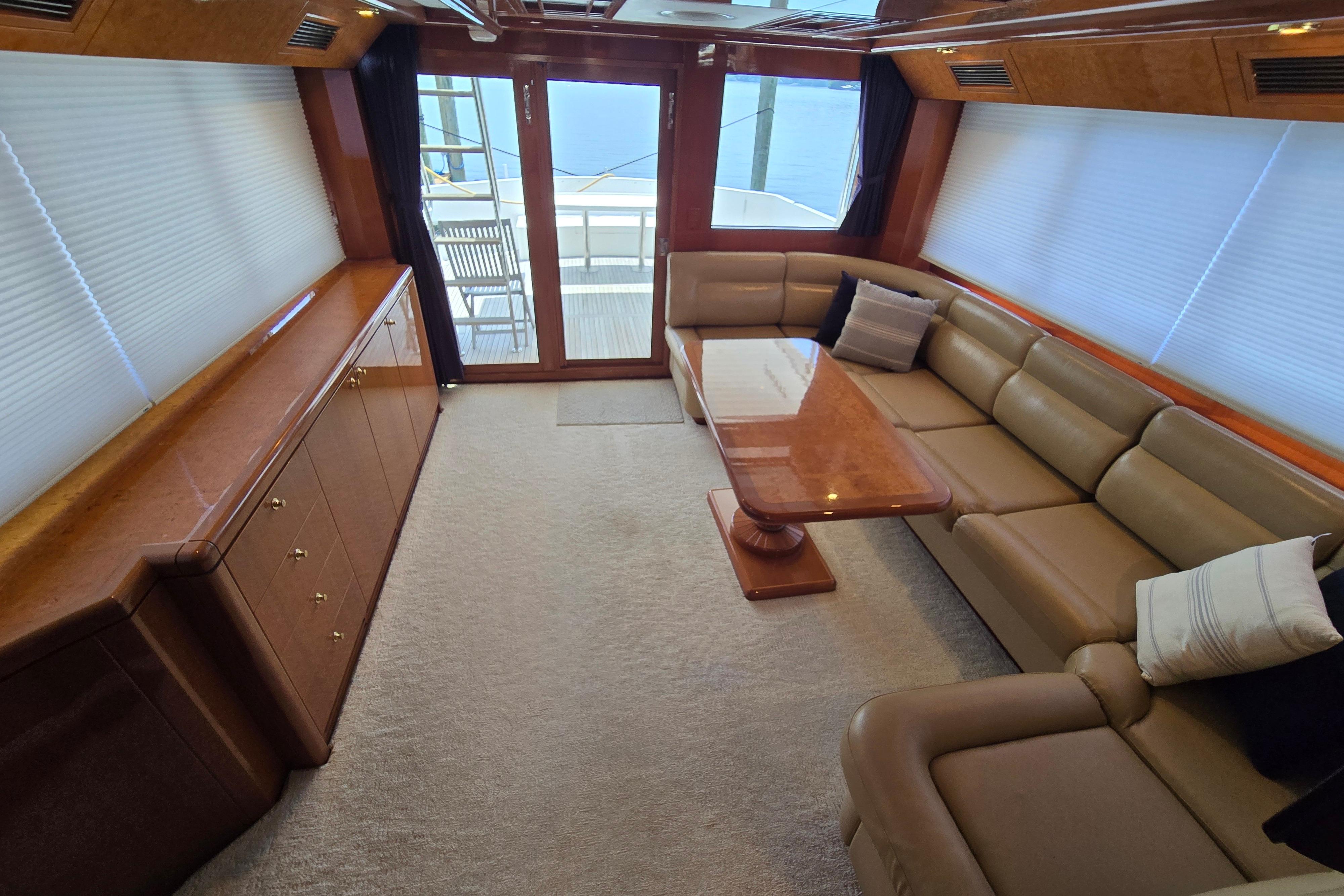 Luxurious interior of 2004 Grand Harbour 58 yacht with leather seating and wooden table.