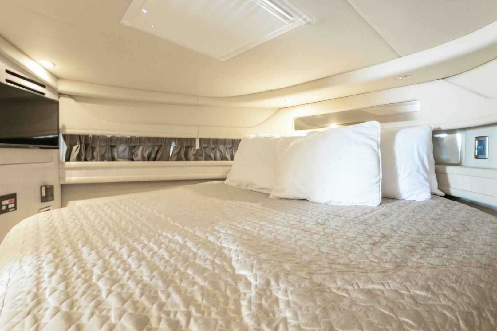 Luxurious cabin interior of 2003 Sea Ray Sundancer 460 yacht with cozy bedding.