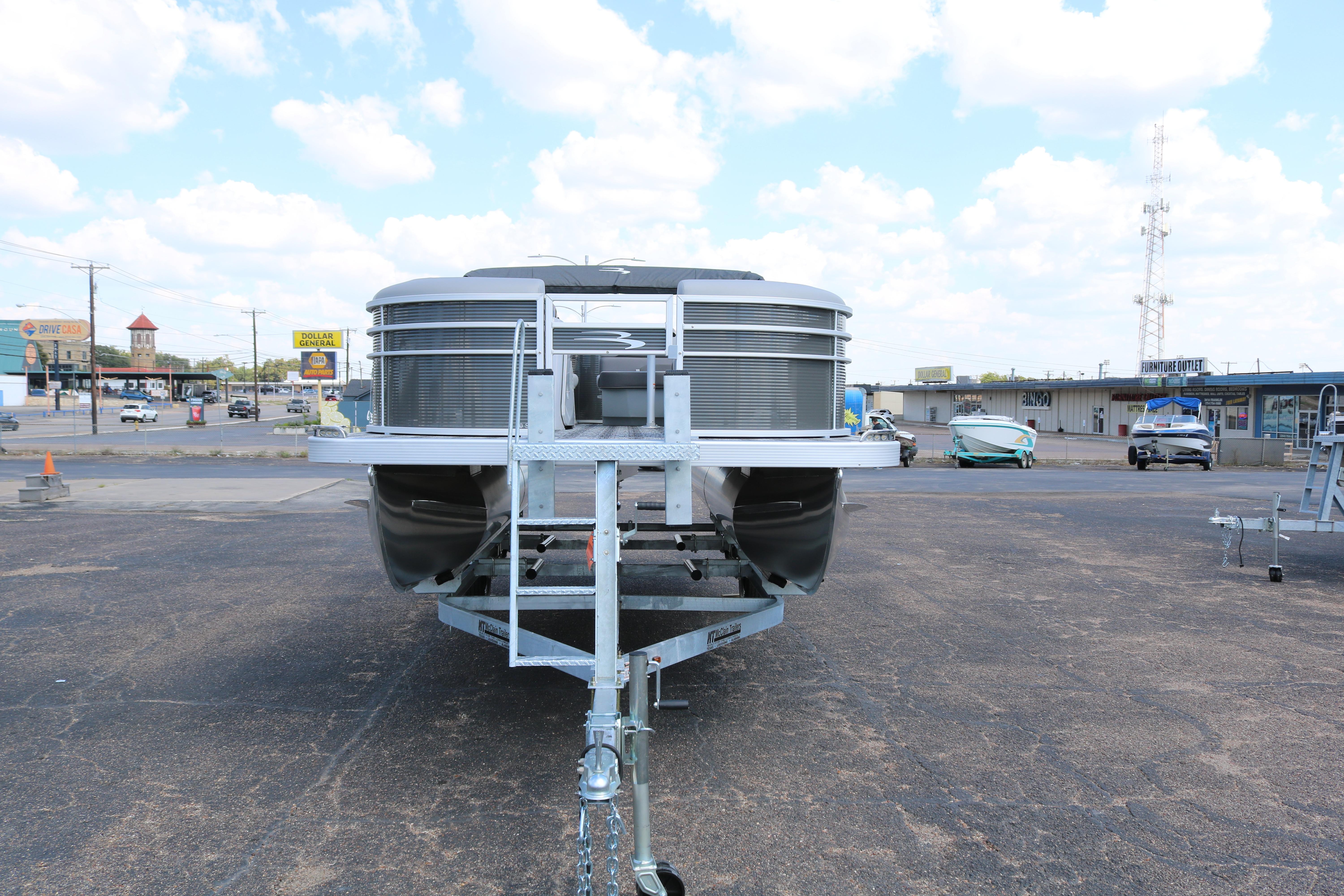 2026 Bennington 20SXSNP REAR FISH pontoon boat on trailer in parking lot.