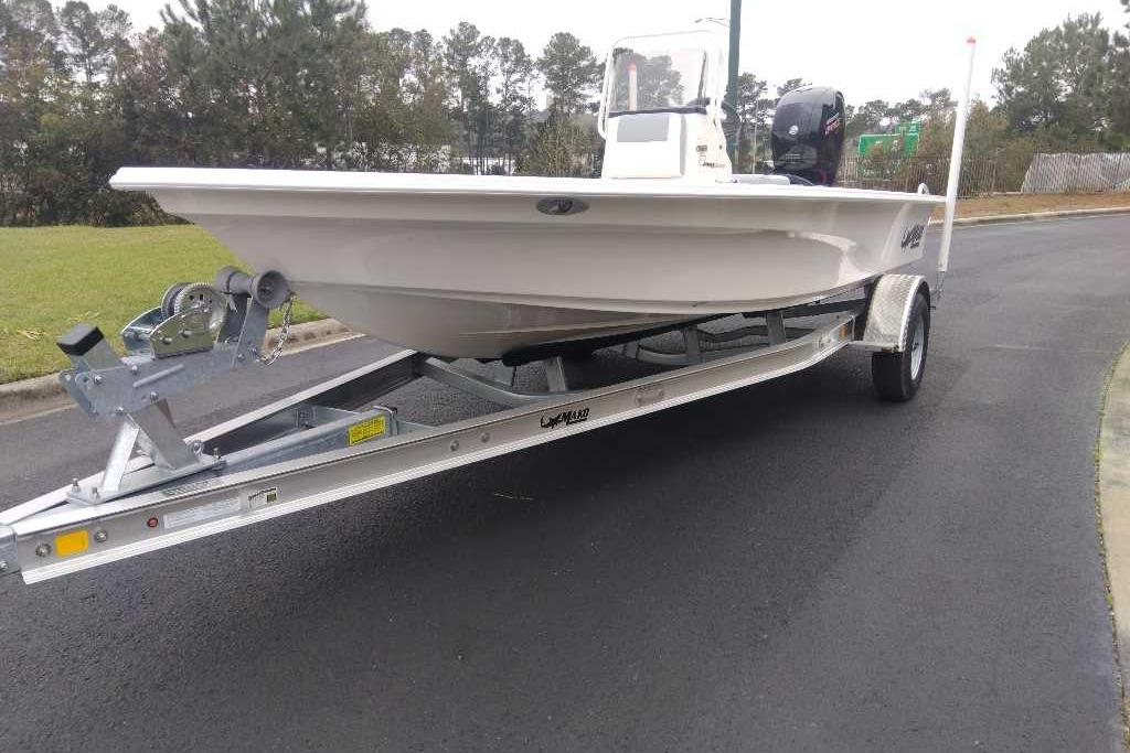 2026 Mako 18 Pro Skiff boat on trailer, parked on a paved road.