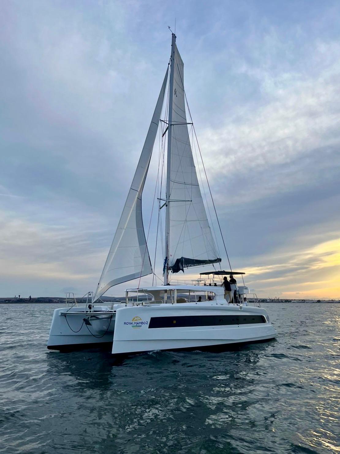 Aventura 45 catamaran sailing at sunset, 2026 model, on calm waters.