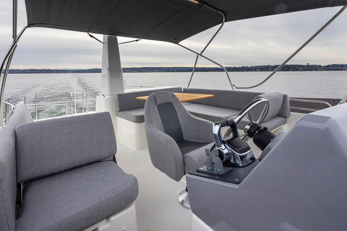 2026 Beneteau Swift Trawler 41 Flybridge with modern seating and steering, cruising on open water.