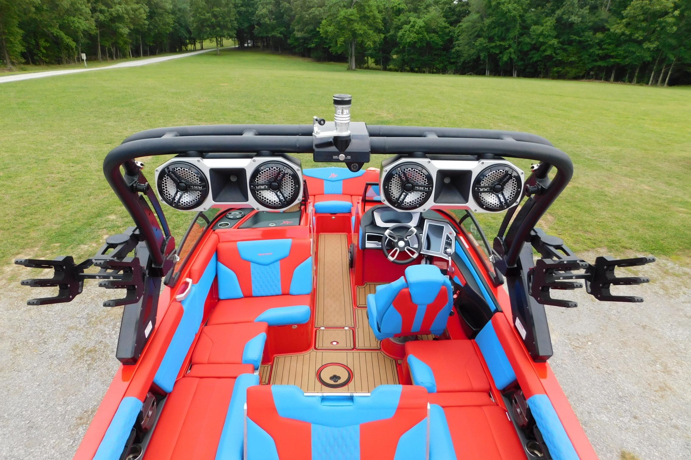 2022 MasterCraft NXT24 boat interior with vibrant red and blue seating, advanced audio system.