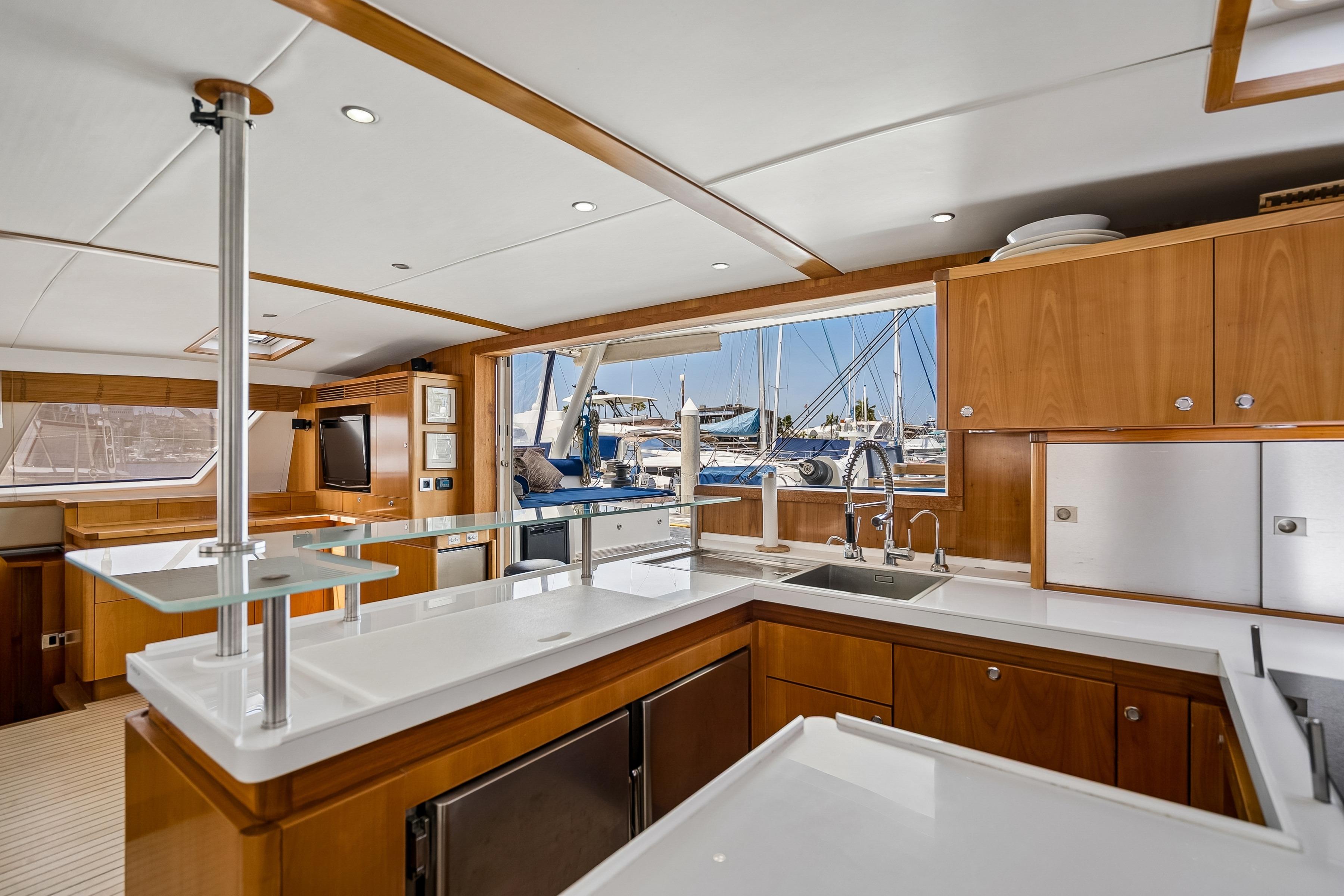 Luxurious interior of 2009 Catana 65 yacht with modern kitchen and marina view.