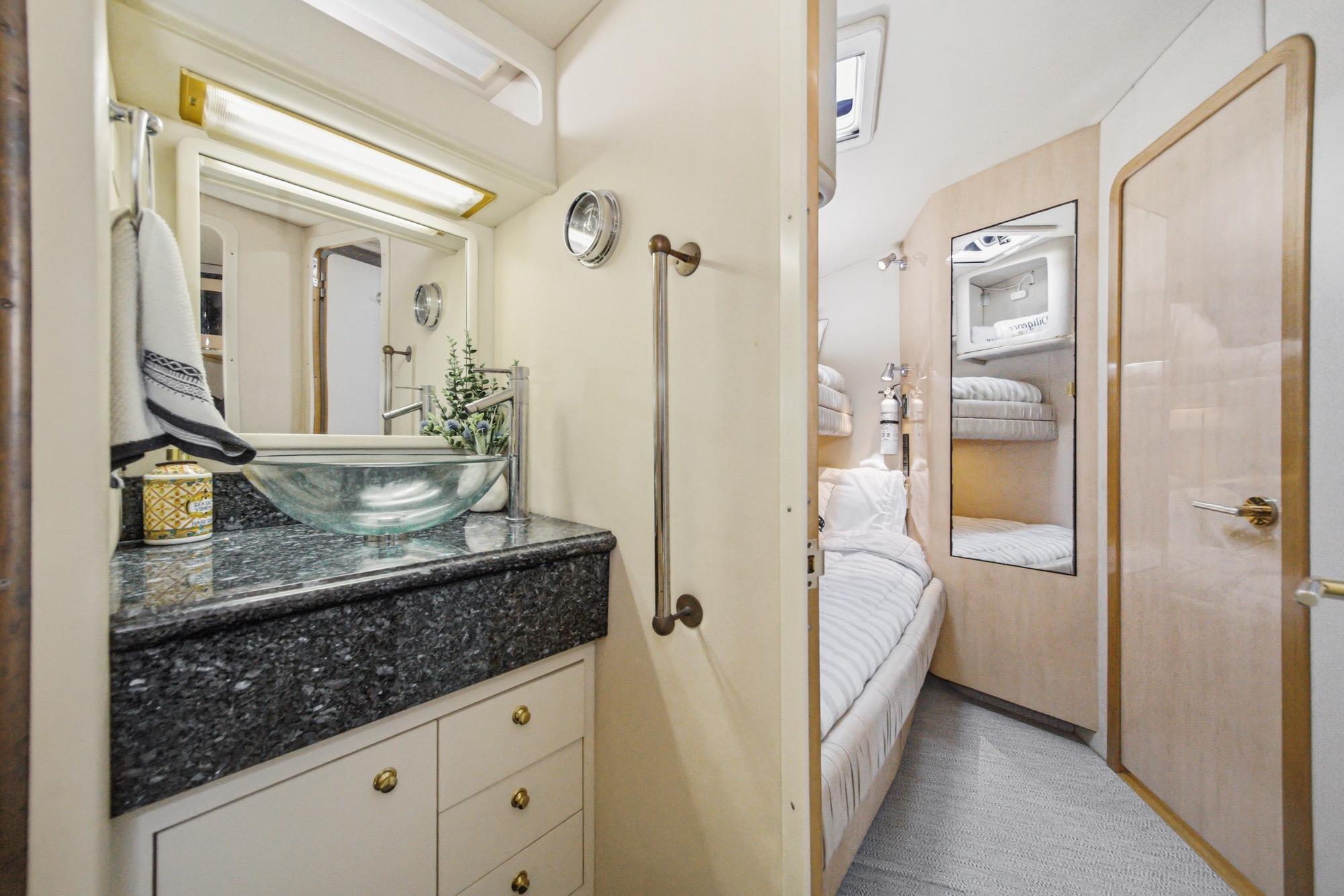 Luxurious 1999 Sea Ray 500 Sundancer yacht interior with elegant bathroom and cozy bedroom.