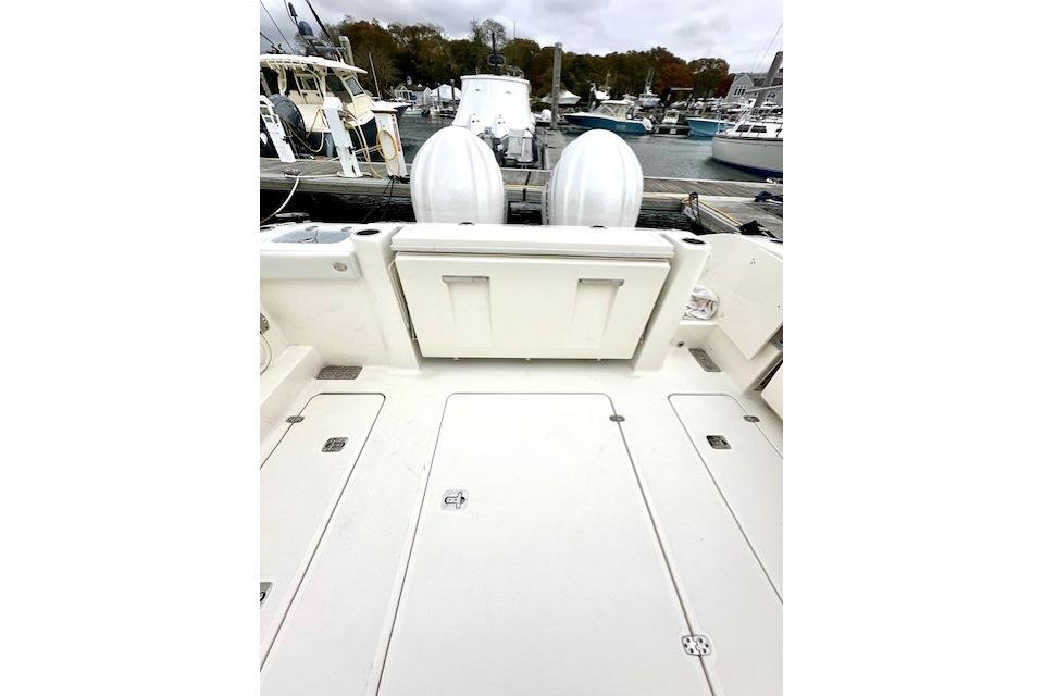 2024 Pursuit DC 326 Dual Console boat deck with twin engines at marina.