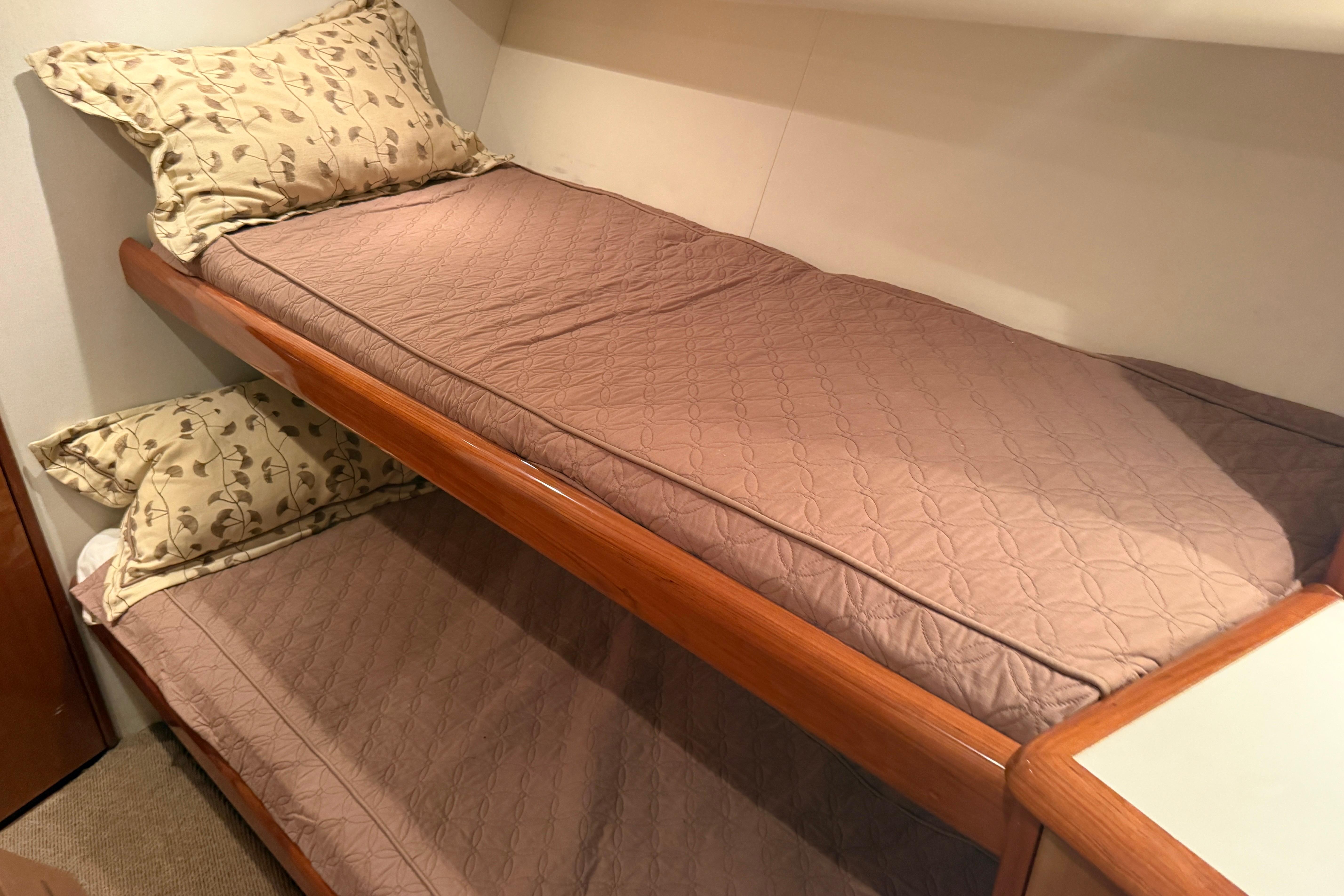 Bunk beds in a 2000 Viking 55 Convertible yacht cabin with patterned bedding.