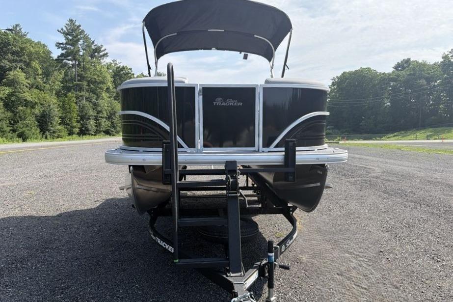 2026 Sun Tracker Party Barge 20 DLX pontoon boat on trailer, parked outdoors.