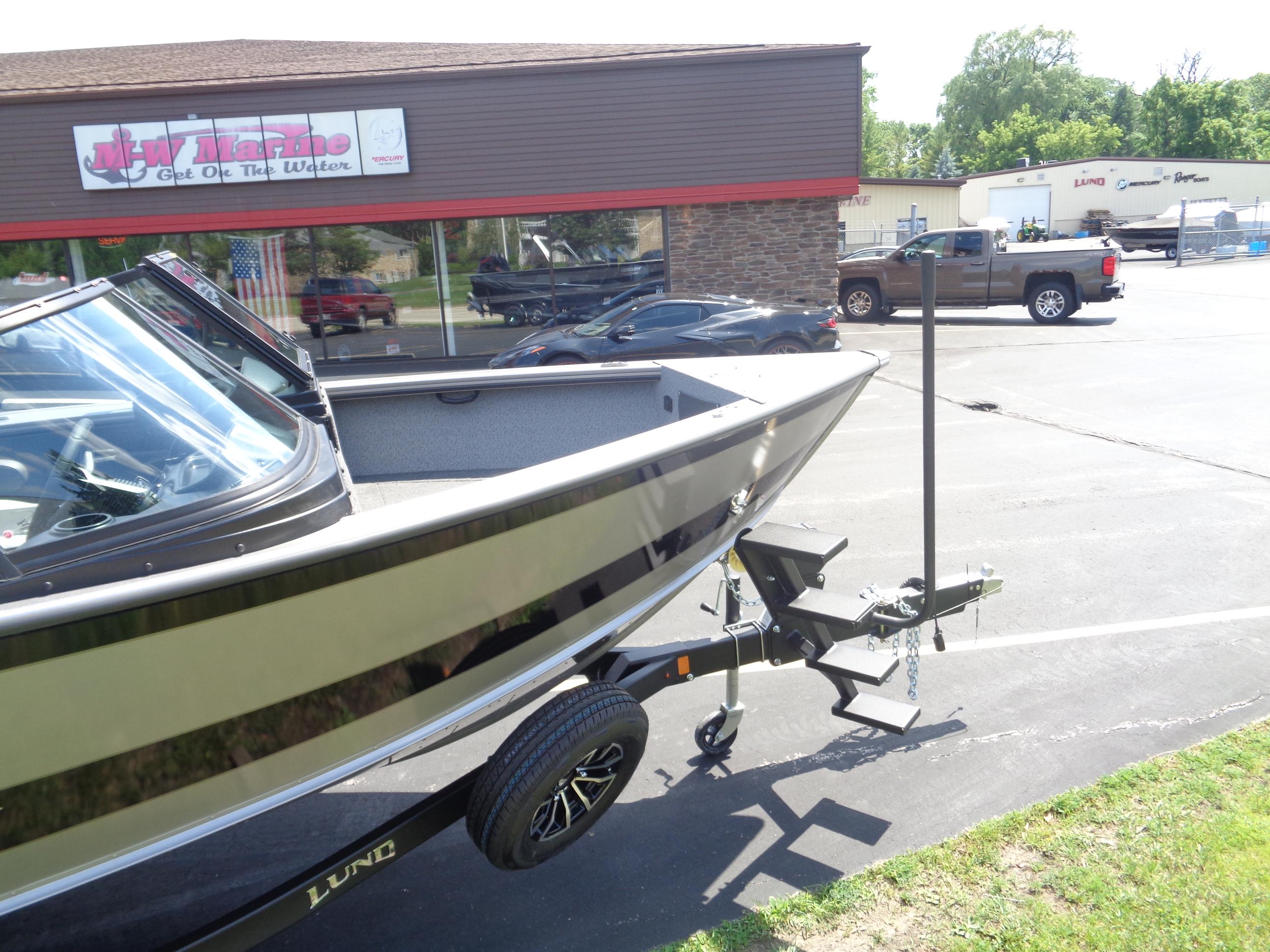 2025 Lund 2075 Fisherman boat on trailer outside marine store.