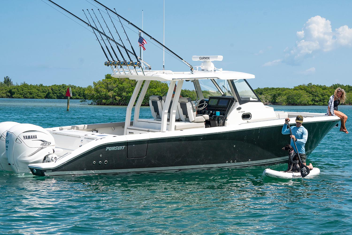 Manufacturer Provided Image: 2025 Pursuit S 358 Sport boat on water with fishing rods and paddleboarder nearby.