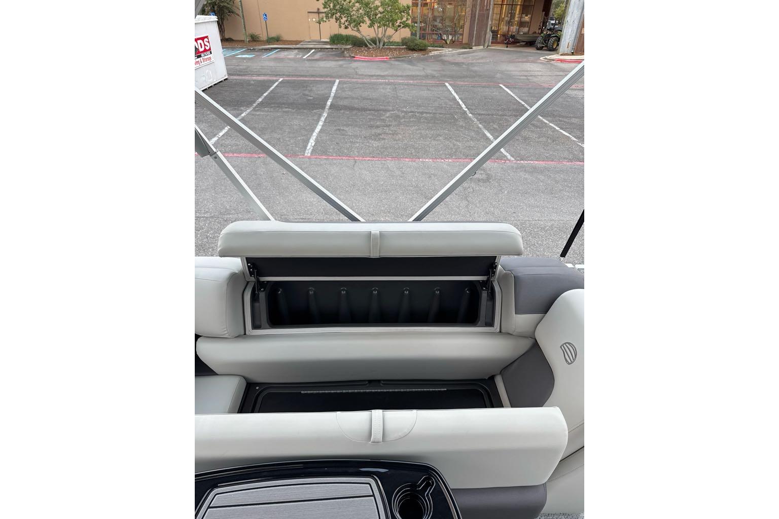 2026 Sun Tracker Fishin' Barge 22 DLX interior seating with storage compartment open.