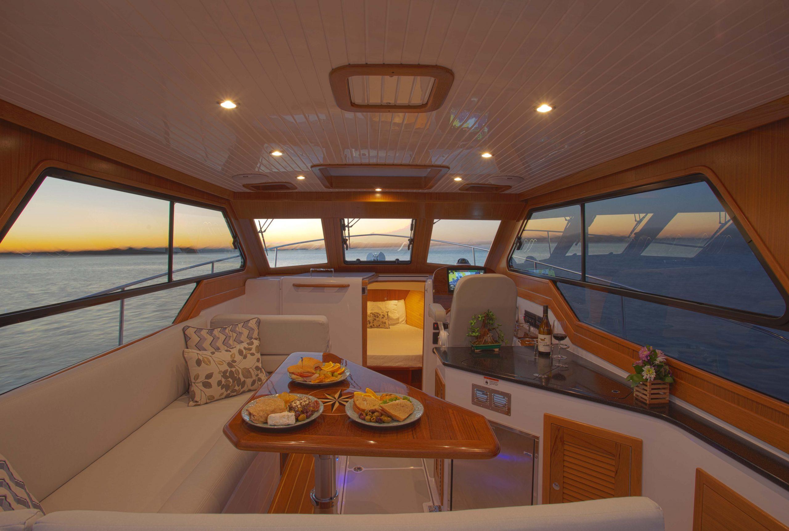 Luxurious 2024 True North 34 yacht interior with sunset view and elegant dining setup.
