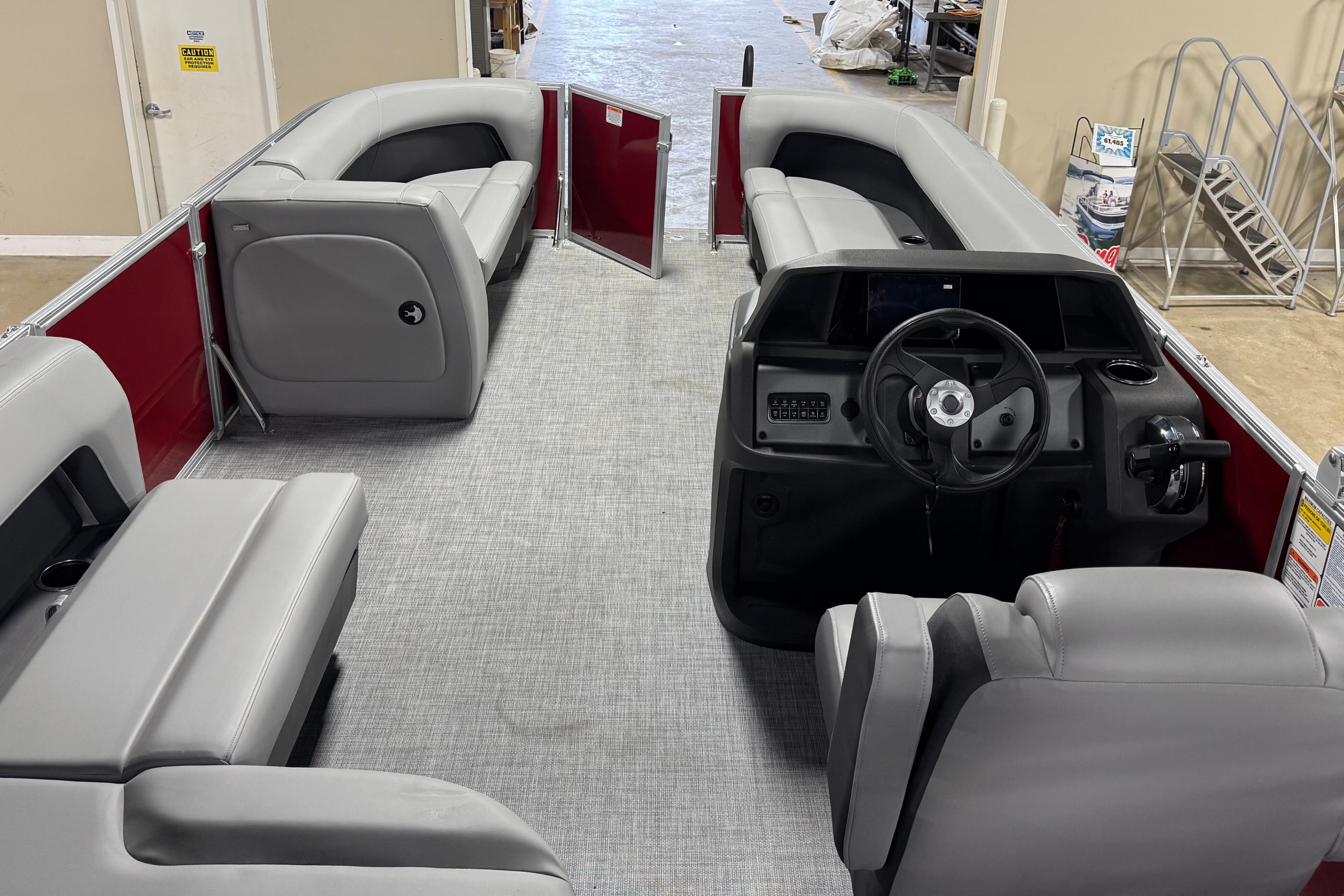 2026 Sun Tracker Party Barge 18 DLX interior with gray seating and steering console.