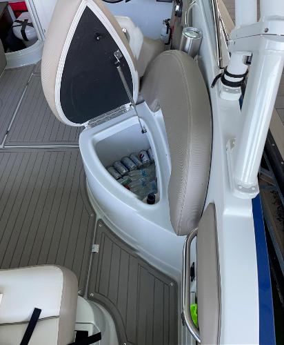 2019 Crownline E255 boat interior with open storage compartment and beverage cans.
