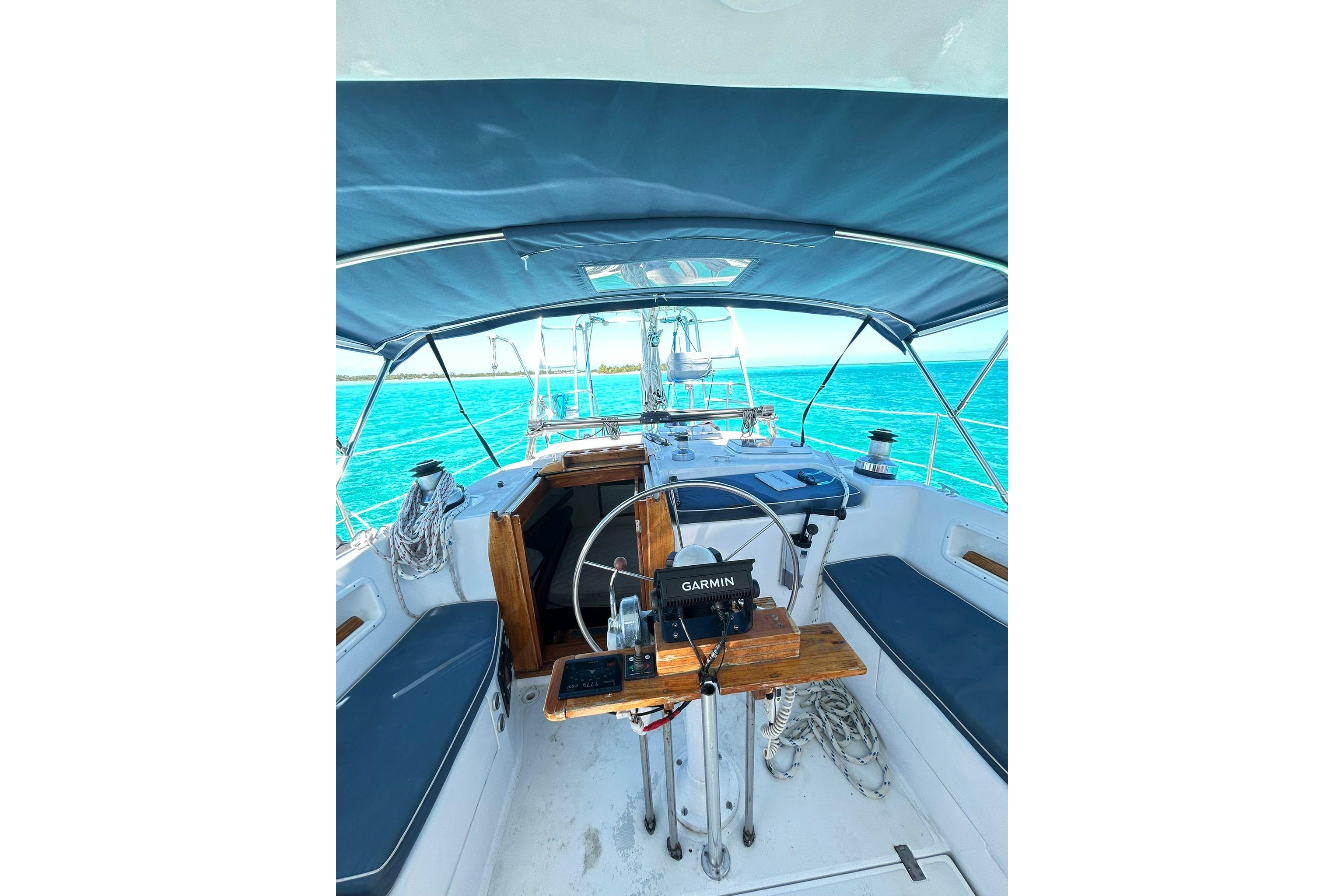 1987 Gulfstar CSY 50 Pilot House cockpit with Garmin navigation, overlooking turquoise ocean waters.
