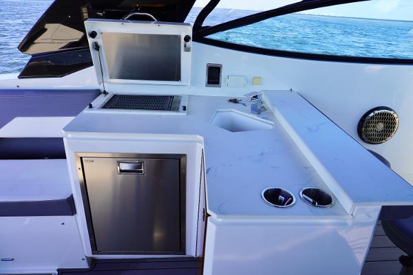 Outdoor kitchen on 2020 Cruisers Yachts 38 GLS OB, featuring grill and sink.