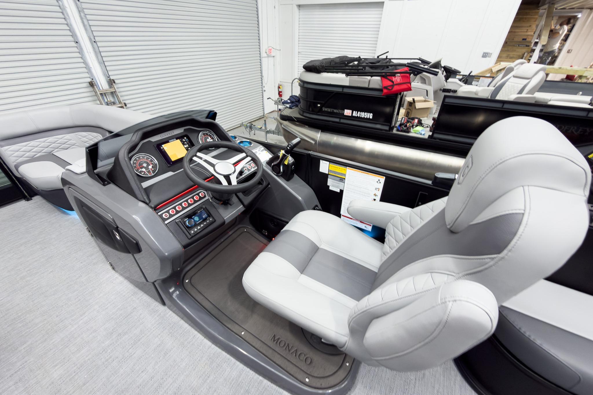 Interior view of 2026 Godfrey Monaco 25' Tritoon, featuring modern helm and seating.