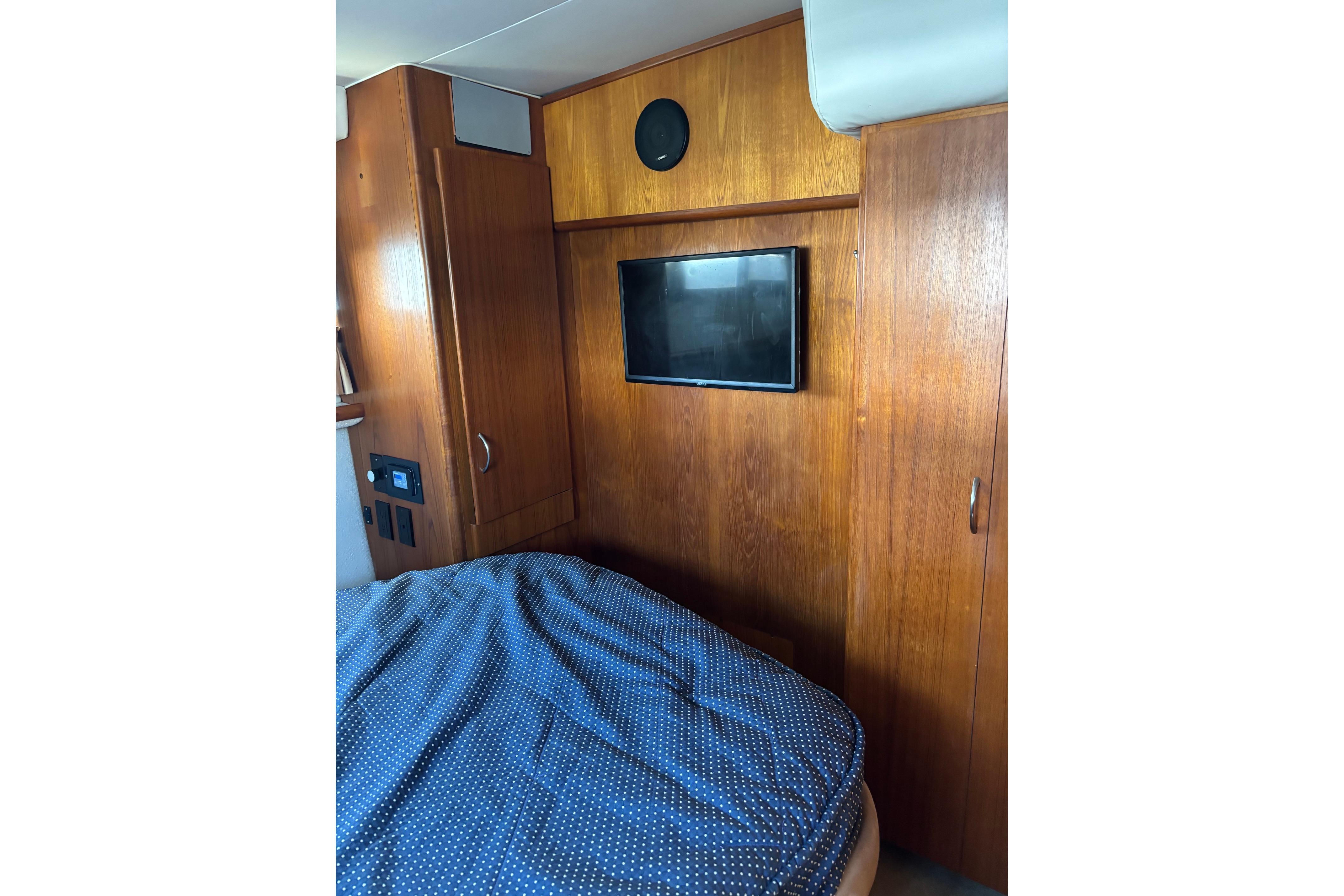 Interior of 1995 Carver 356 Aft Cabin Motor Yacht with wood paneling and TV.