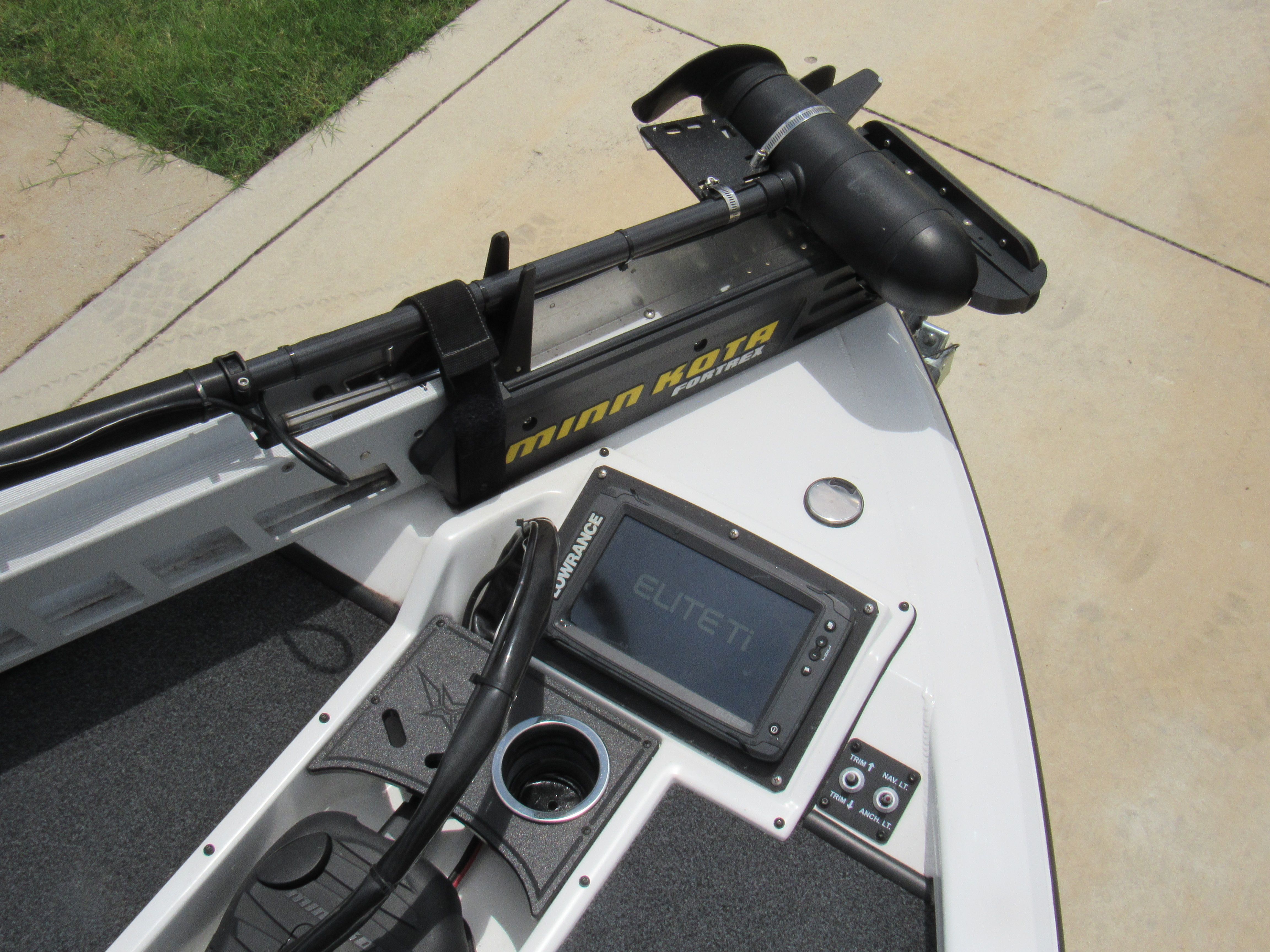 Close-up of a boat deck featuring a fish finder and a motor.