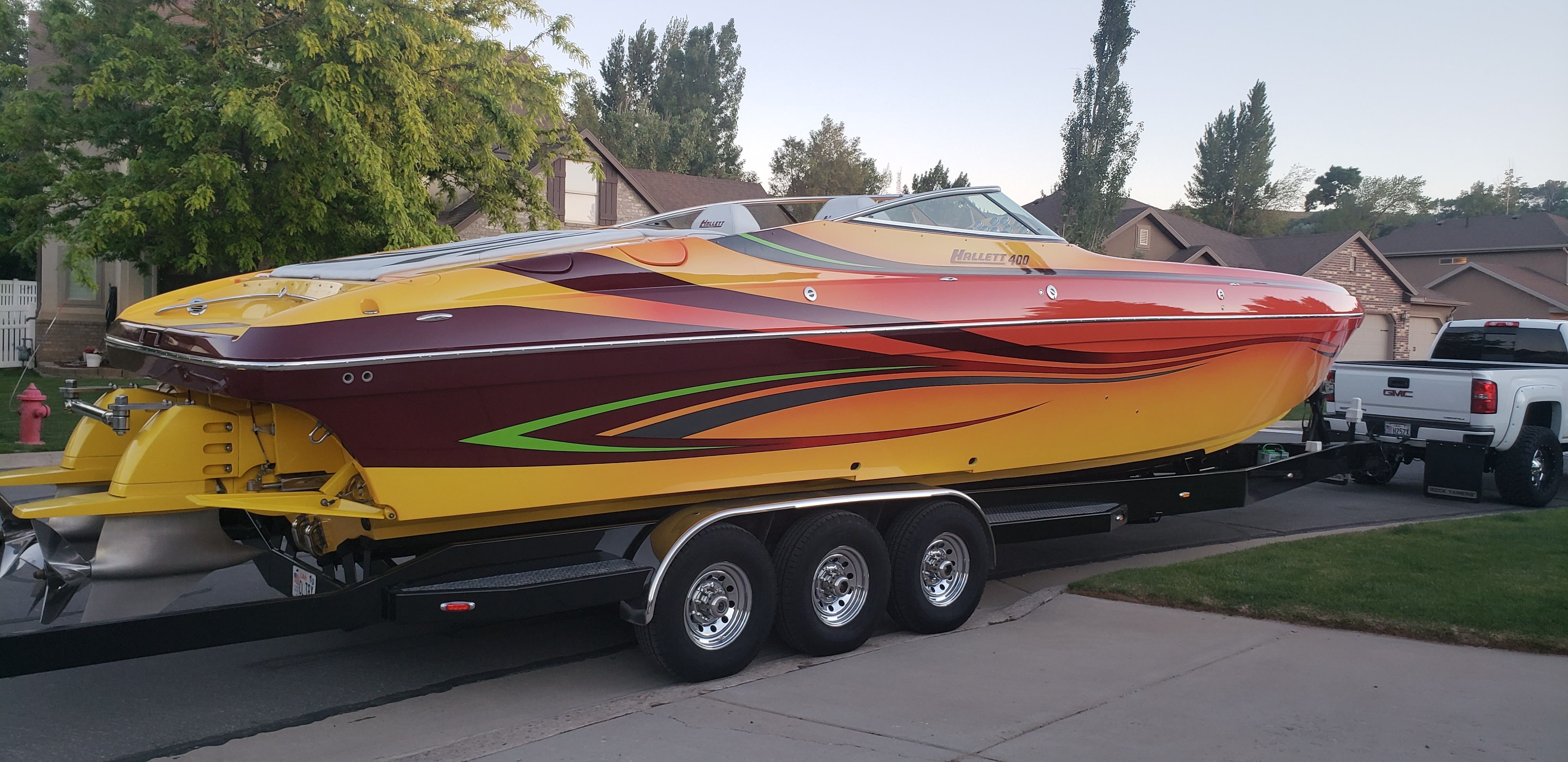 2009 Hallett 400T boat on trailer in residential area.