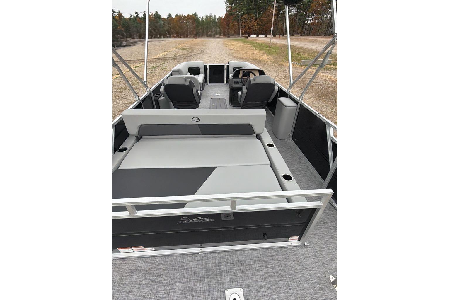 2026 Sun Tracker Party Barge 22 RF XP3 interior with seating and helm, parked on land.