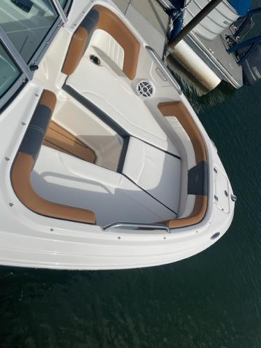 2025 Chaparral 21 SSi boat with tan and gray seating, docked on water.