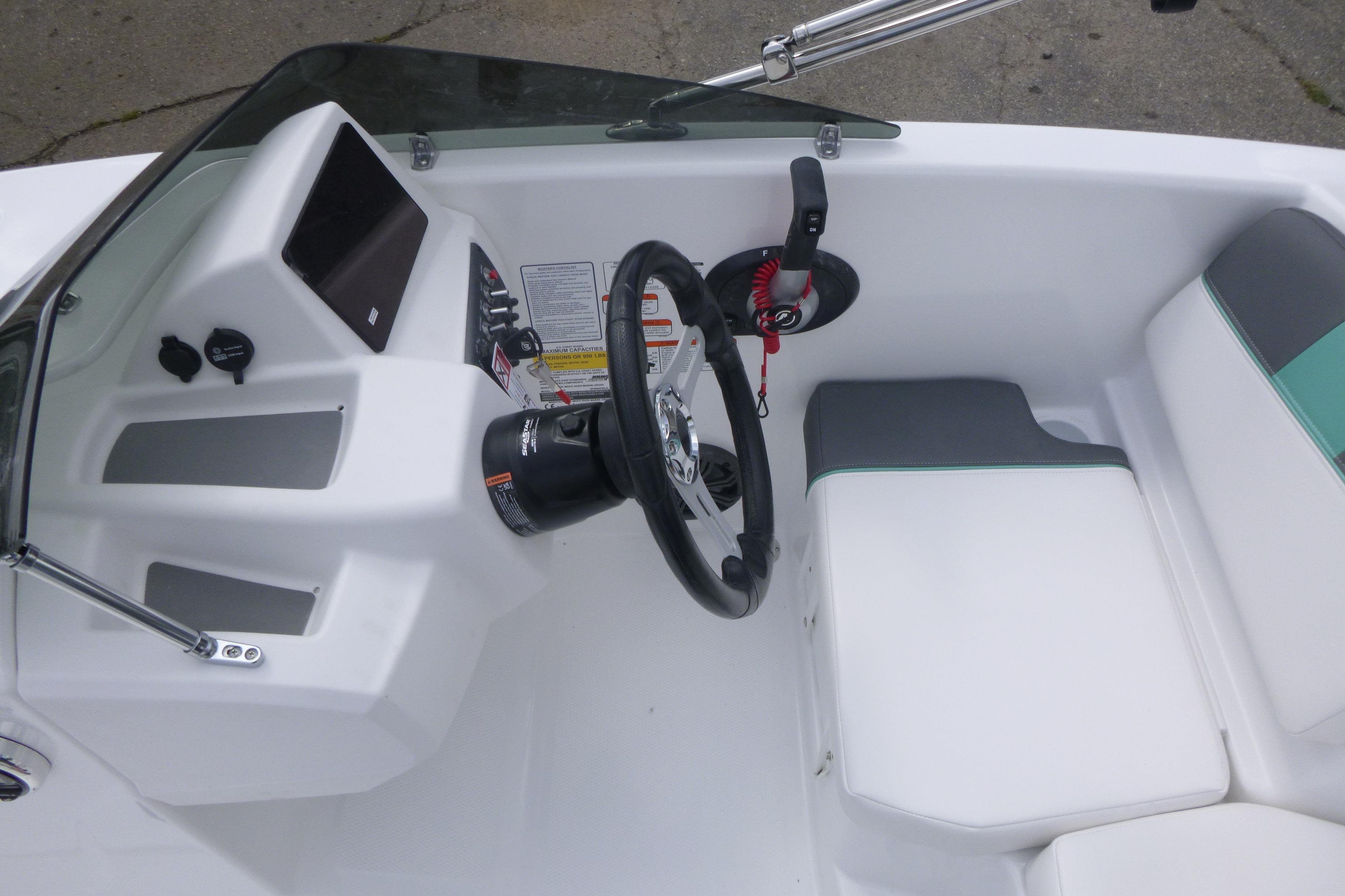 Interior view of 2026 Tahoe T16 boat cockpit with steering wheel and seating.