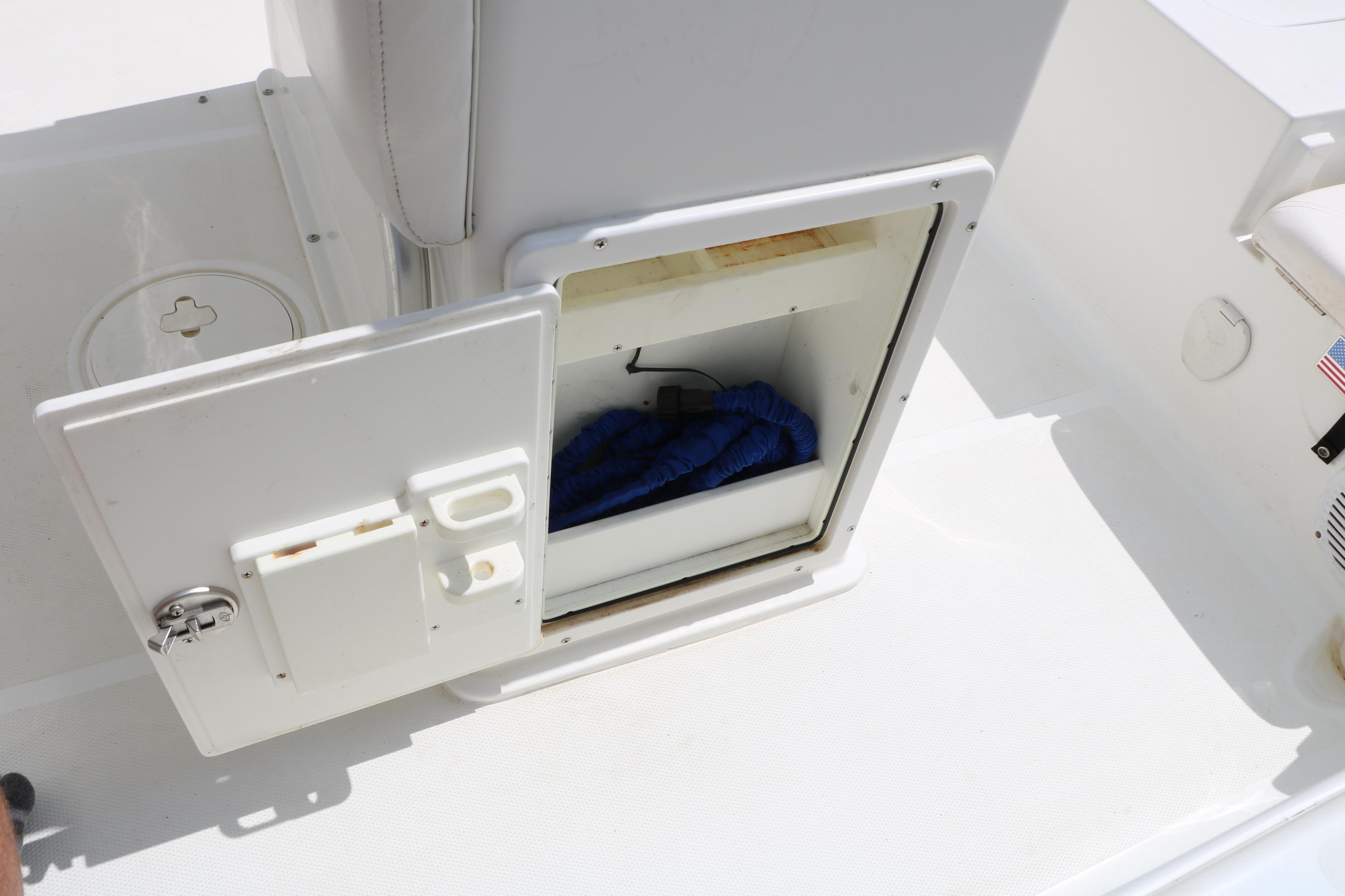 Open storage compartment on a 2015 Sea Hunt BX 22 BR boat deck.