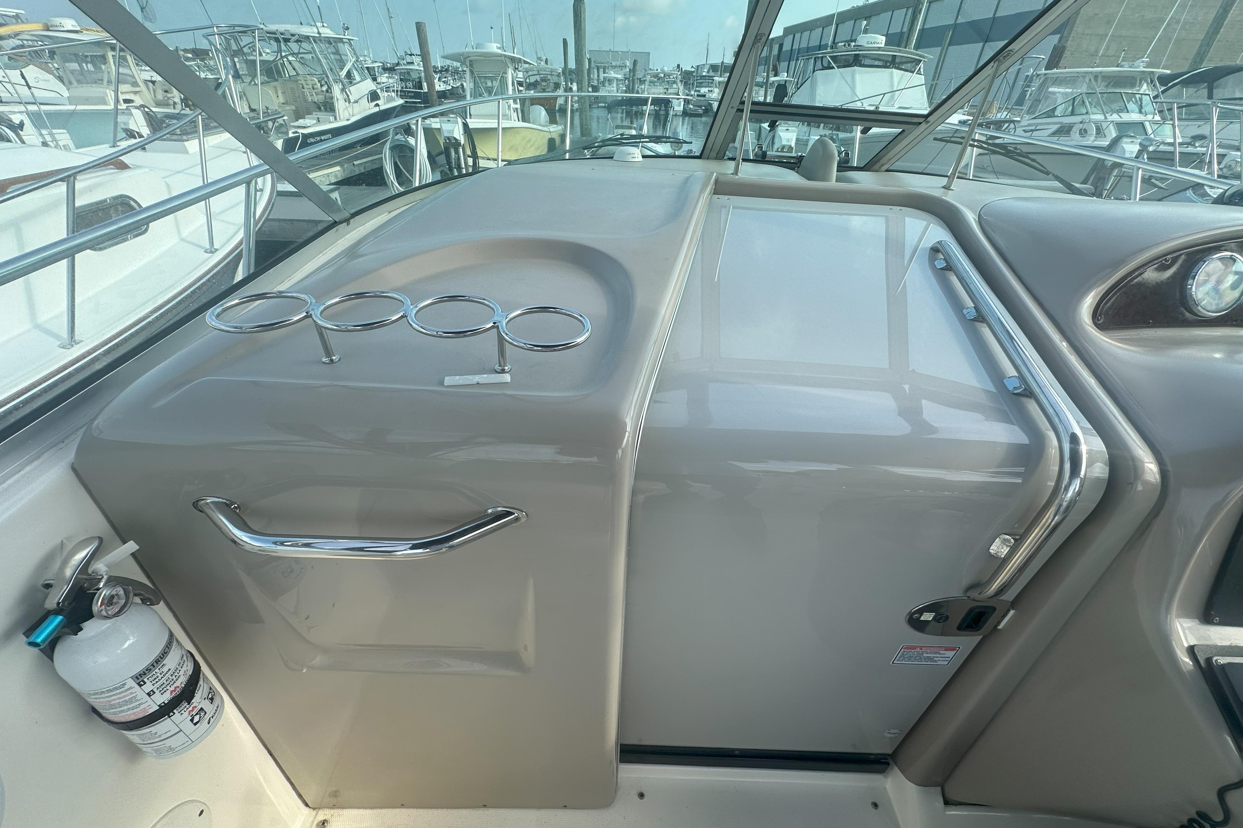 2006 Sea Ray 290 Amberjack cockpit with cup holders and fire extinguisher, docked at marina.