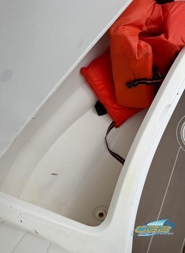 Storage compartment in 2008 Sea Ray 270 SLX boat with orange life jackets.