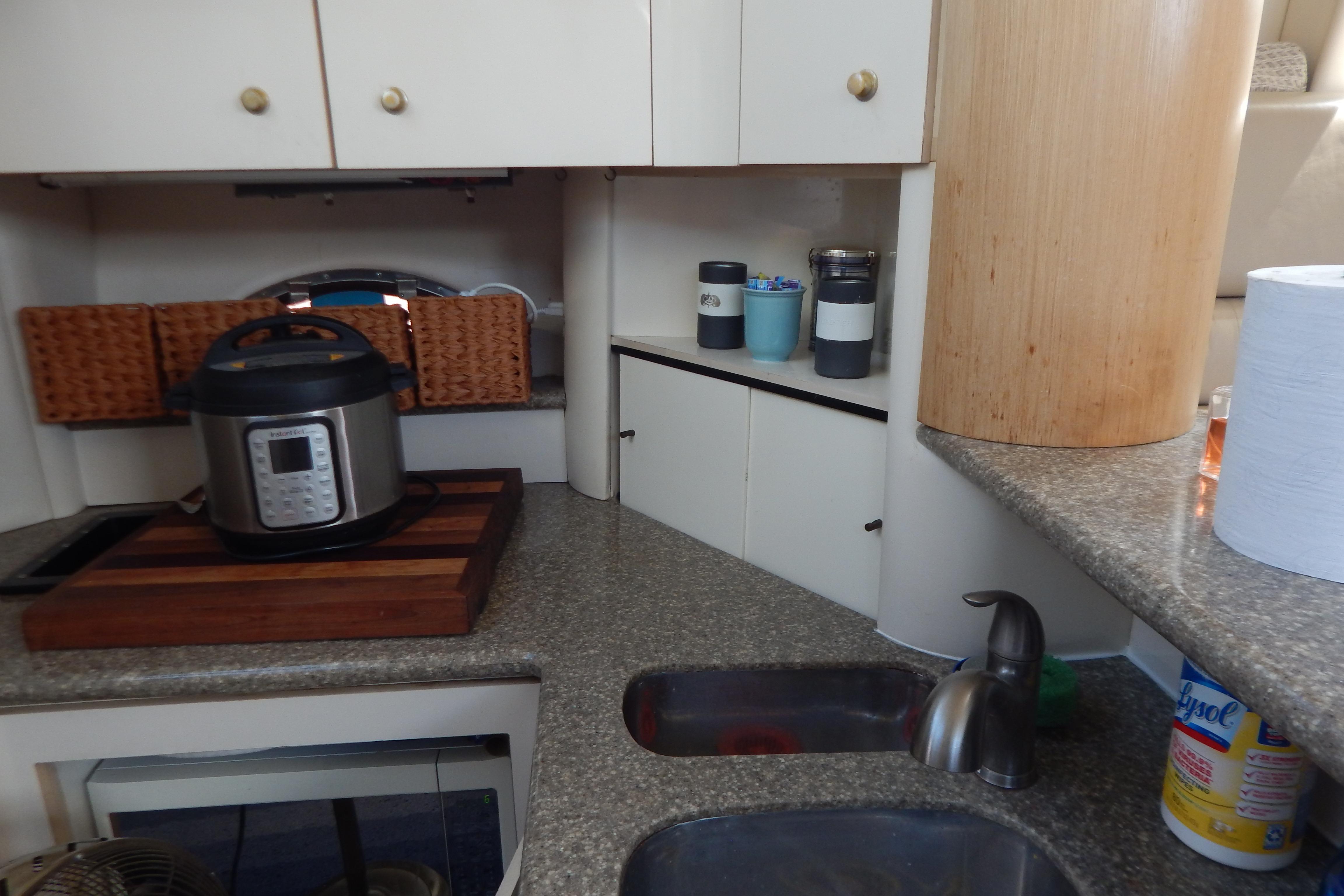 Compact kitchen area in a 1998 Magnum 4100 SCR boat with modern appliances.