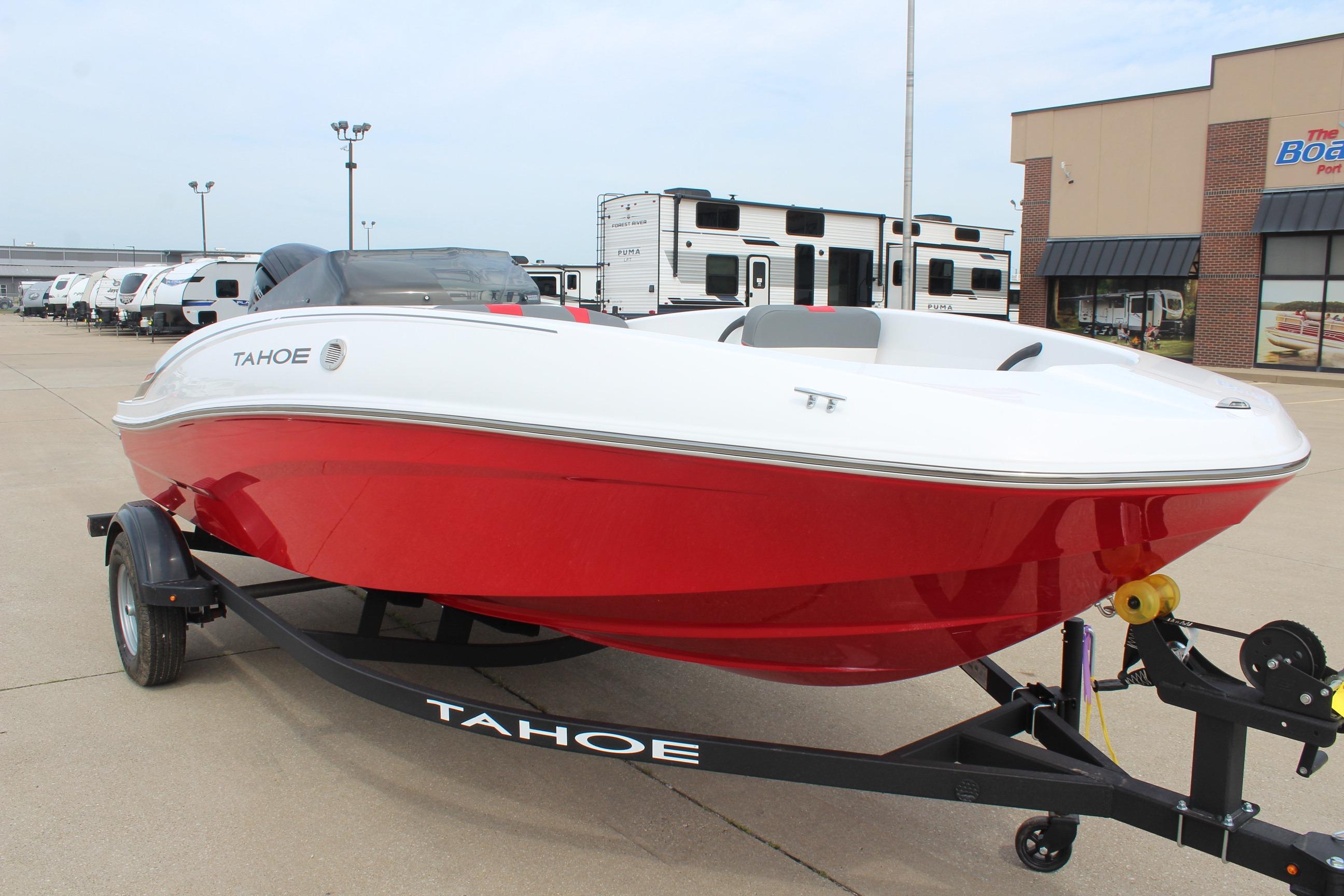 2026 Tahoe T16 boat with red and white design on a trailer in a dealership lot.
