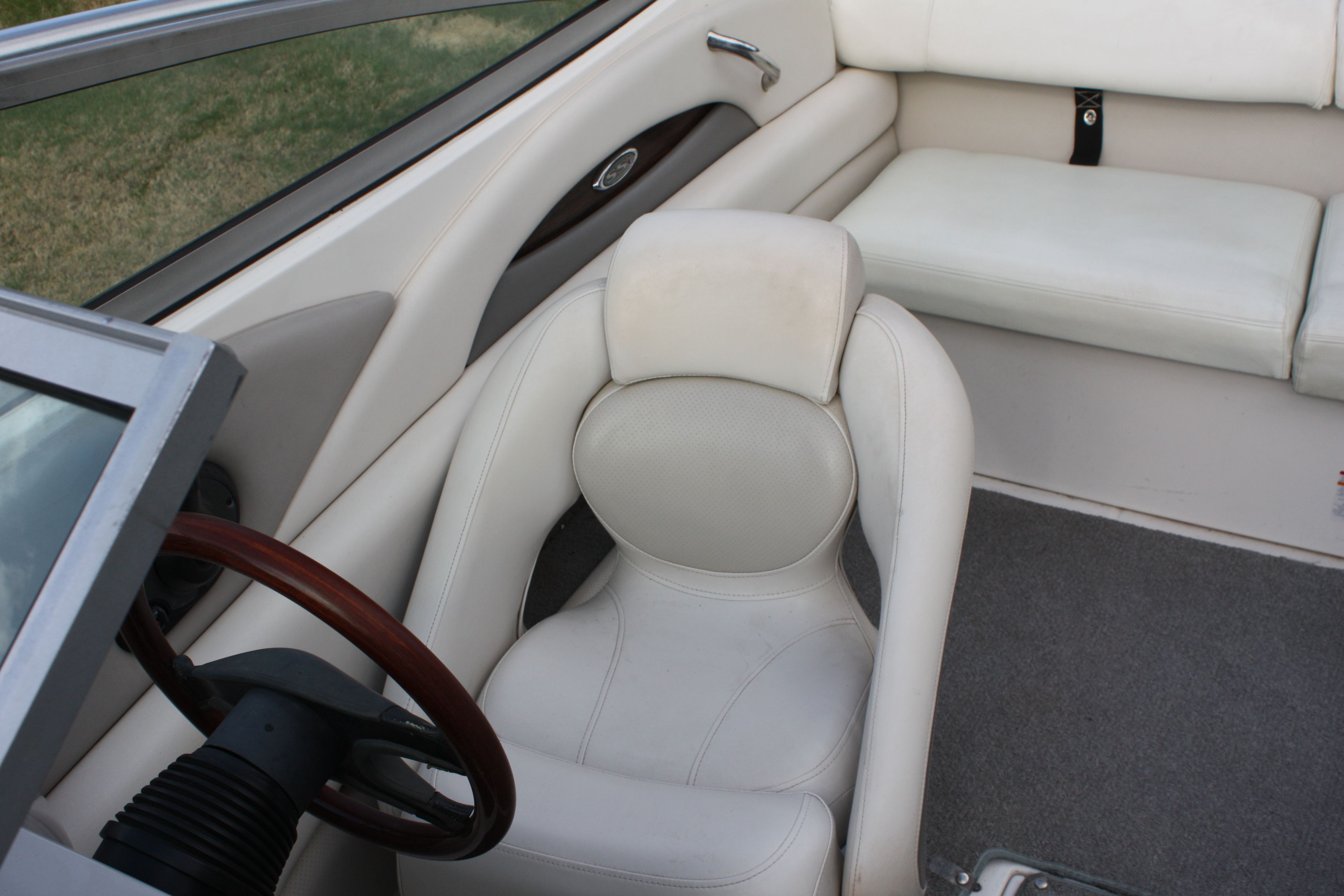 Interior of a 2007 Chaparral 210 SSi with white leather seats and a wooden steering wheel.