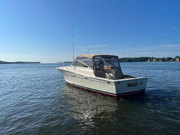 A 1985 Viking 35 Express boat on calm water with a clear sky.