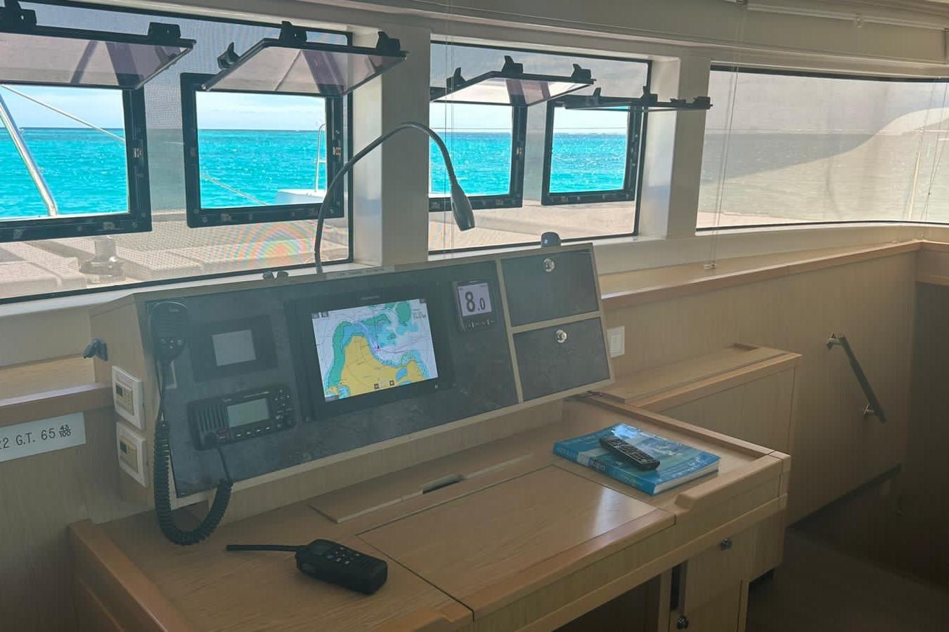 Interior view of 2012 Lagoon 52F yacht cockpit with navigation equipment and ocean view.