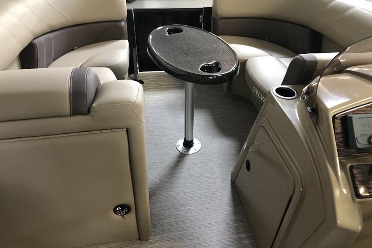 Luxurious interior of 2027 Sylvan Mirage 820 CLZ DH pontoon boat with seating and table.