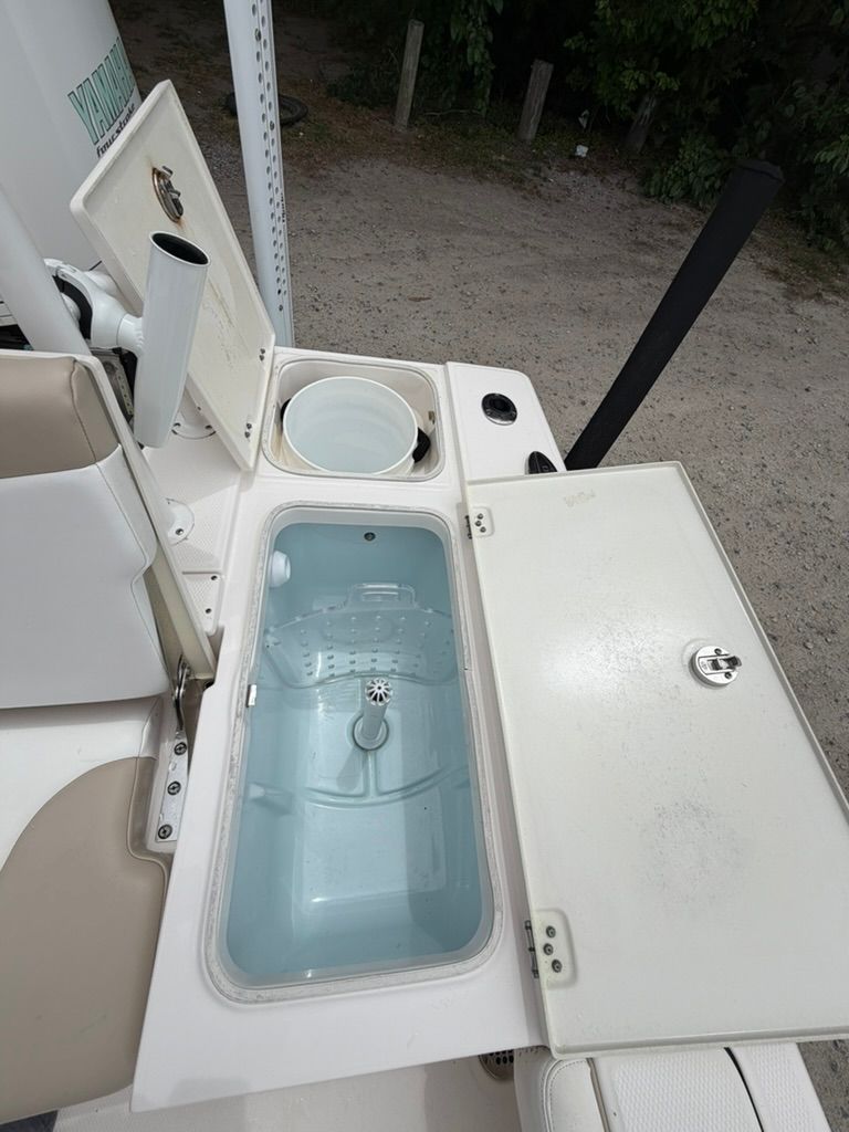 2018 Robalo 246 Cayman SD with open storage and bucket.
