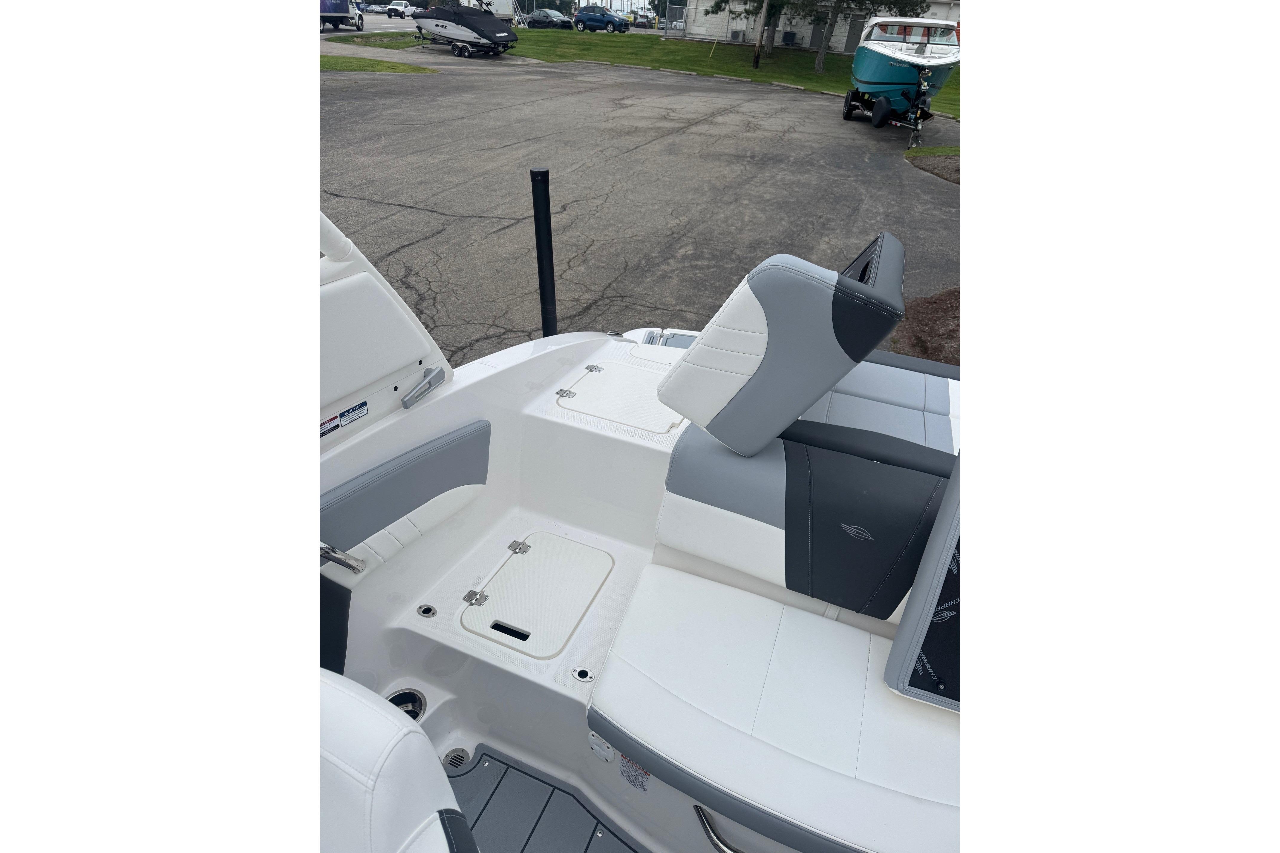 2026 Chaparral 21 SSi boat interior with gray and white seating, docked outdoors.